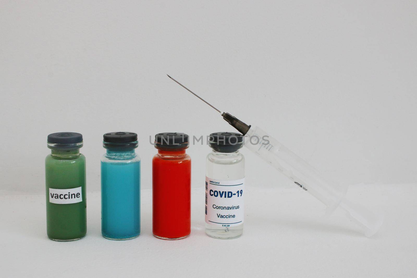 Multi-colored ampoules with vaccine and medicines and a syringe. by gelog67