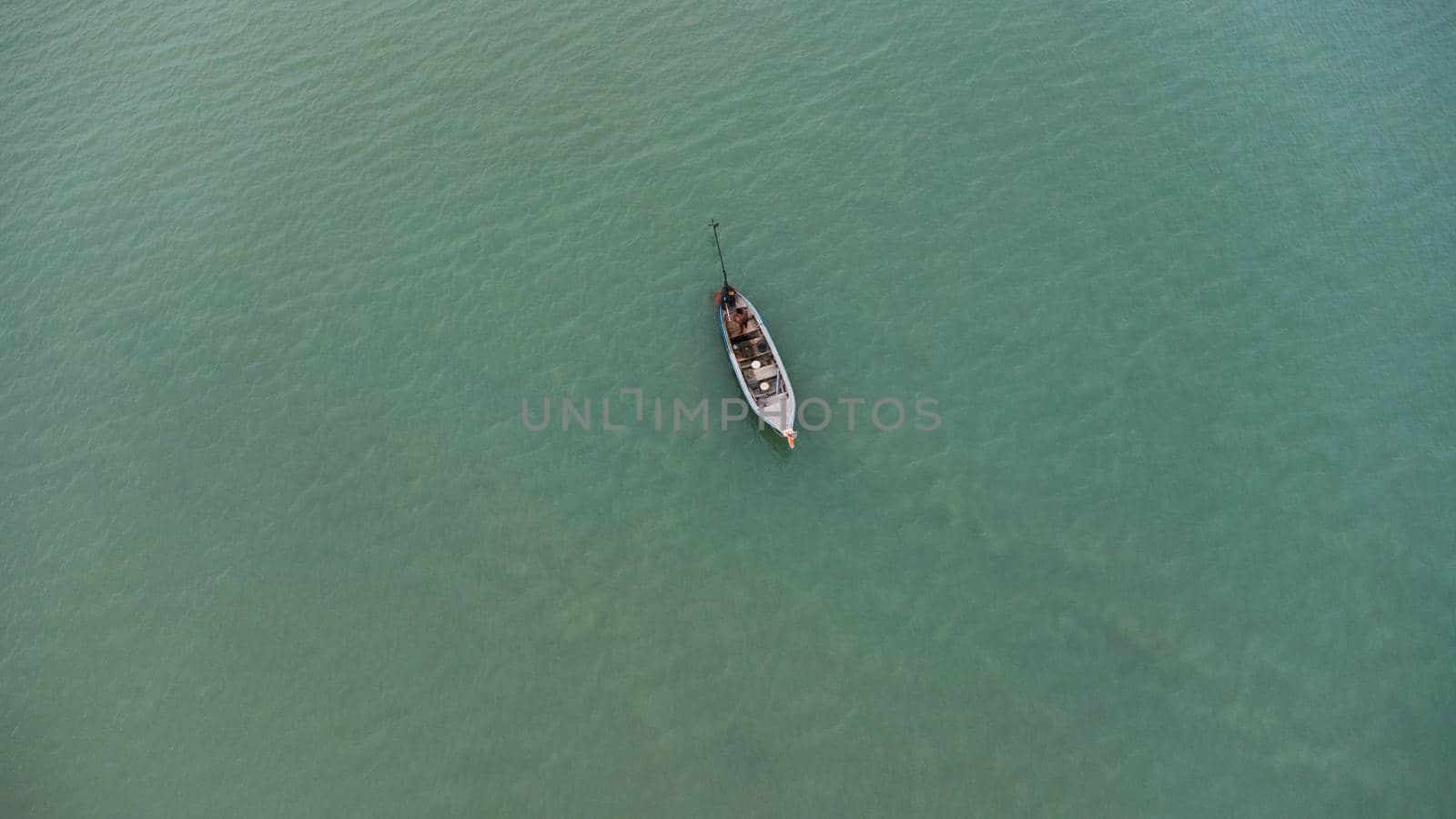 Aerial view from a drone of Thai traditional longtail fishing boats sailing in the sea. Top view of a fishing boat in the ocean.