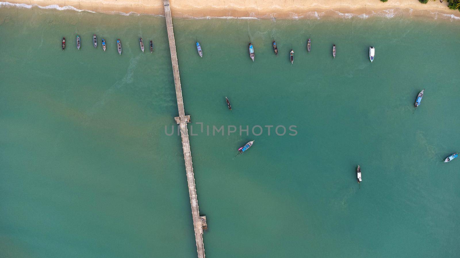 Many fishing boats near the seashore in tropical islands. Pier of the villagers on the southern island of Thailand. top view from drones.