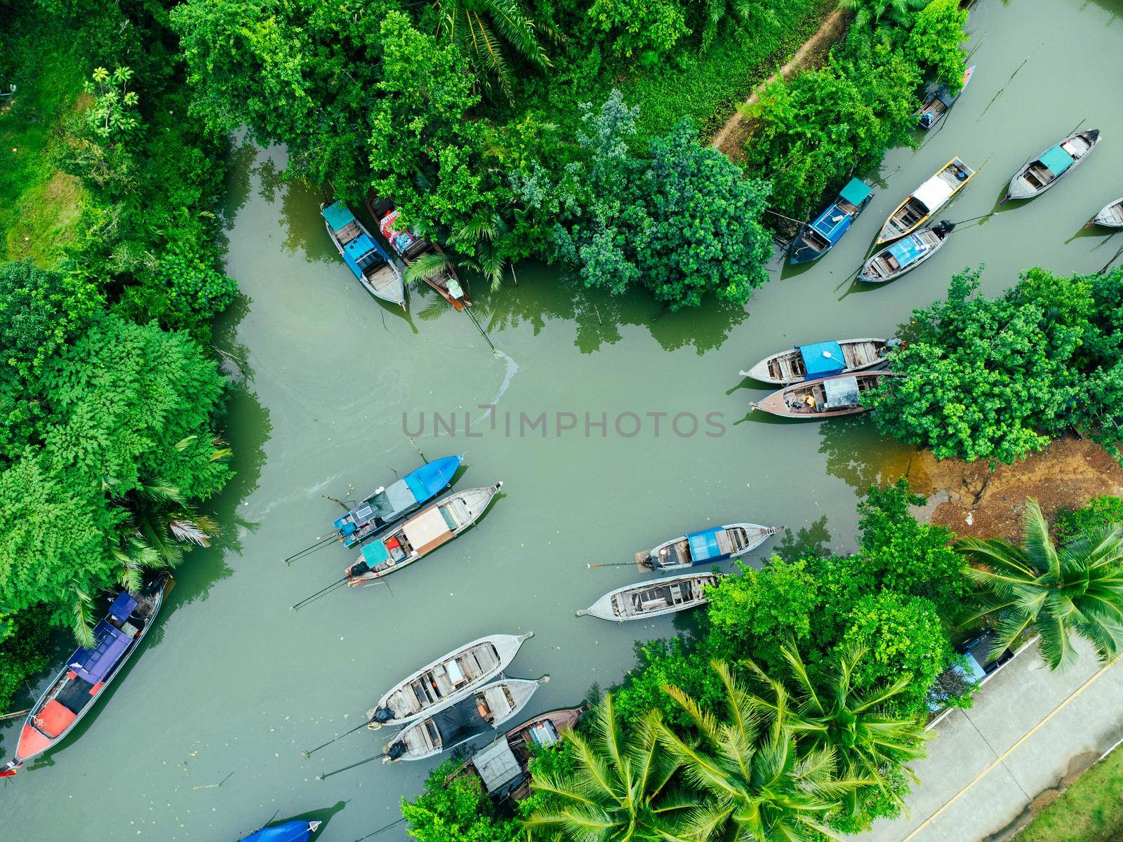 Aerial view from drones of fisherman boats and harbour in the river near the Andaman Sea in southern Thailand. Top view of many Thai traditional longtail boats floating in the mangrove landscape. by TEERASAK