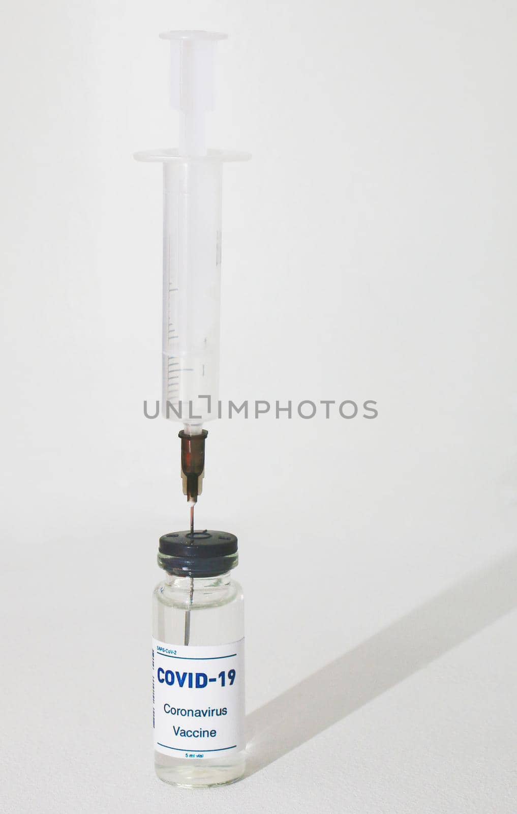 Syringe stuck in an ampoule on a white background. by gelog67