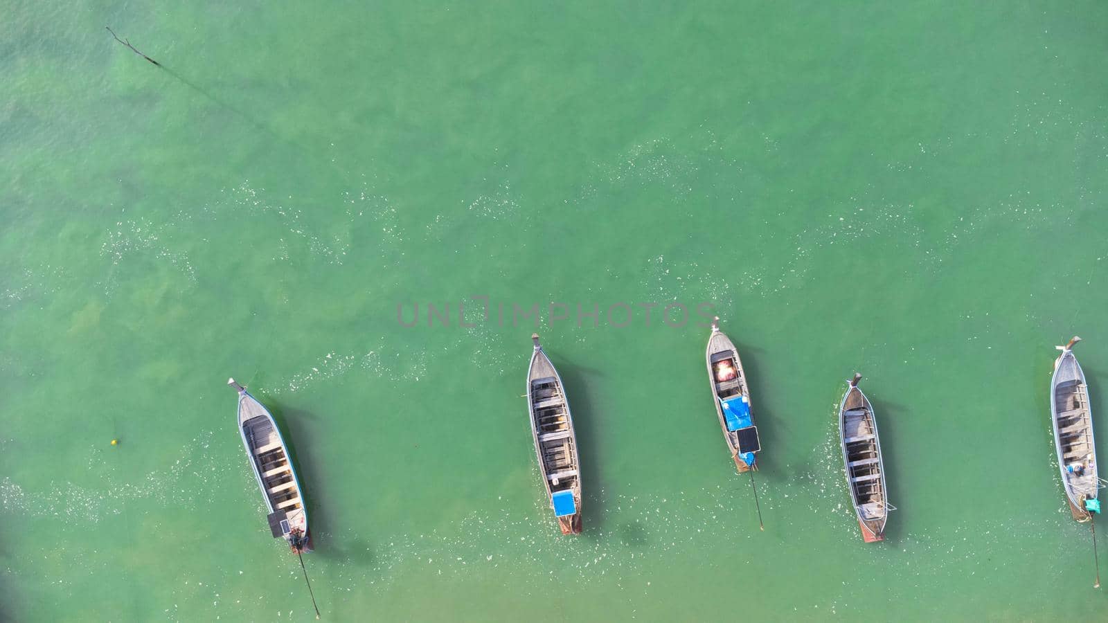 Many fishing boats near the seashore in tropical islands. Pier of the villagers on the southern island of Thailand. top view from drones. by TEERASAK