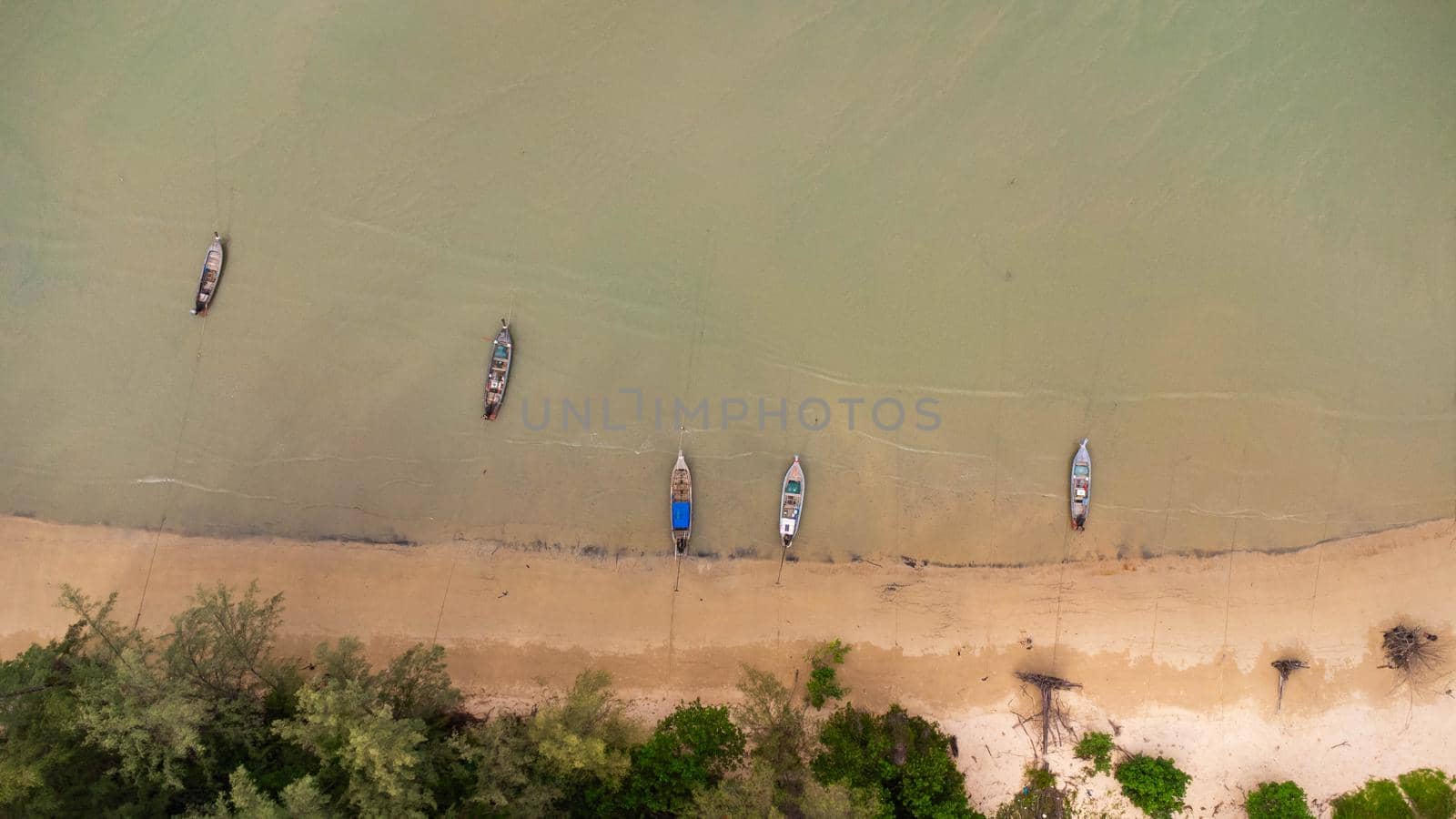 Many fishing boats near the seashore in tropical islands. Pier of the villagers on the southern island of Thailand. top view from drones.