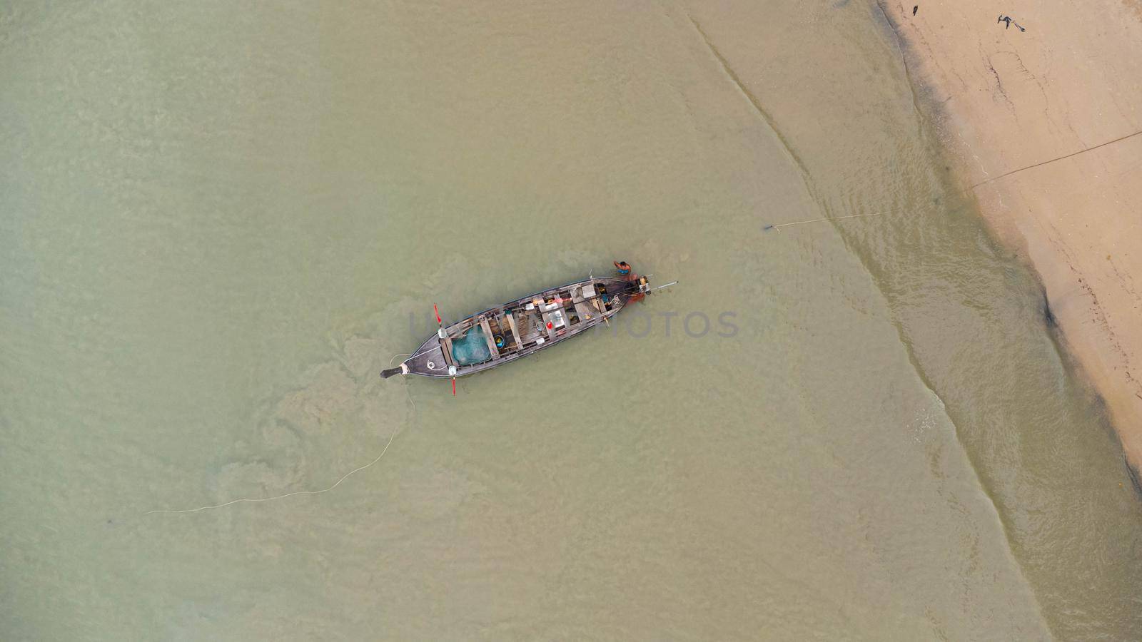Aerial view from drones of fishing boats in the shore during low tide. Top view of Thai traditional longtail fishing boats in the tropical sea. by TEERASAK