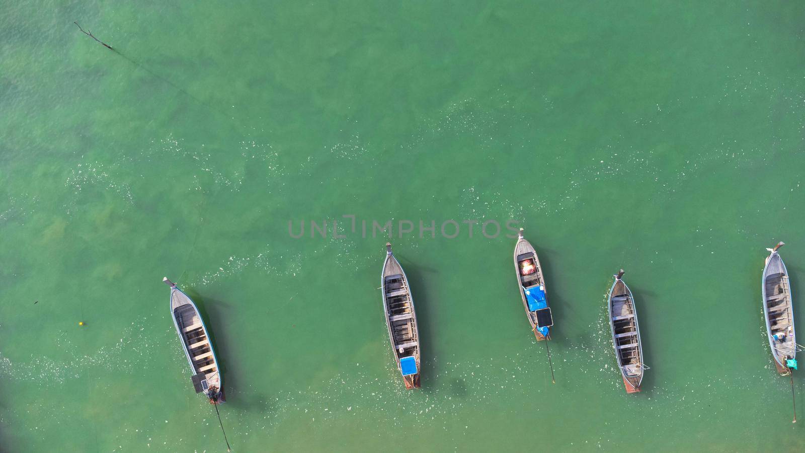 Many fishing boats near the seashore in tropical islands. Pier of the villagers on the southern island of Thailand. top view from drones. by TEERASAK