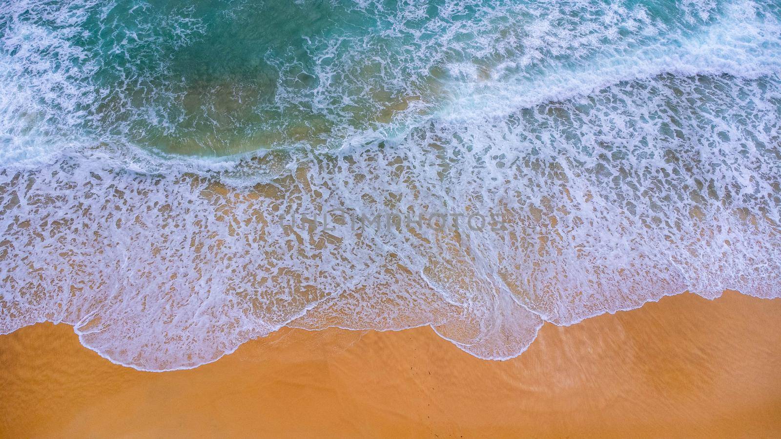 Beautiful sea waves and white sand beach in the tropical island. Soft waves of blue ocean on sandy beach background from top view from drones. Concept of relaxation and travel on vacation. by TEERASAK