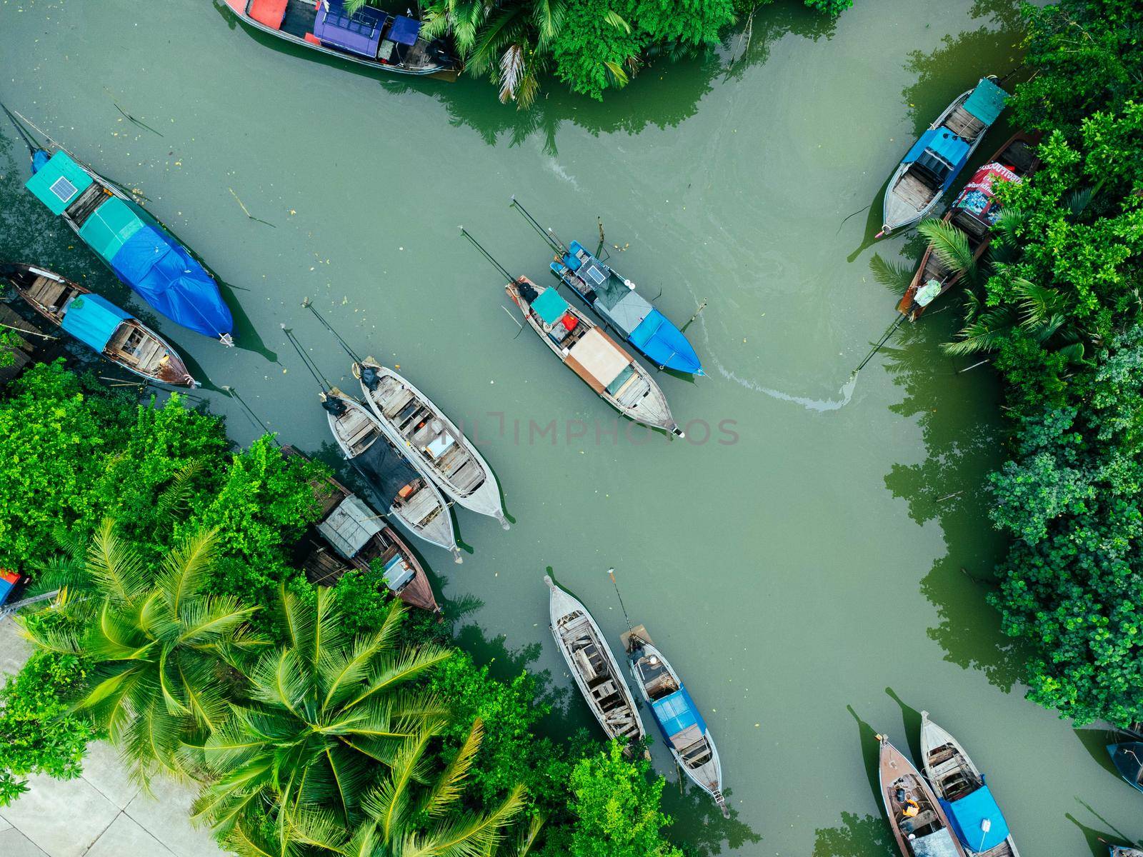 Aerial view from drones of fisherman boats and harbour in the river near the Andaman Sea in southern Thailand. Top view of many Thai traditional longtail boats floating in the mangrove landscape.