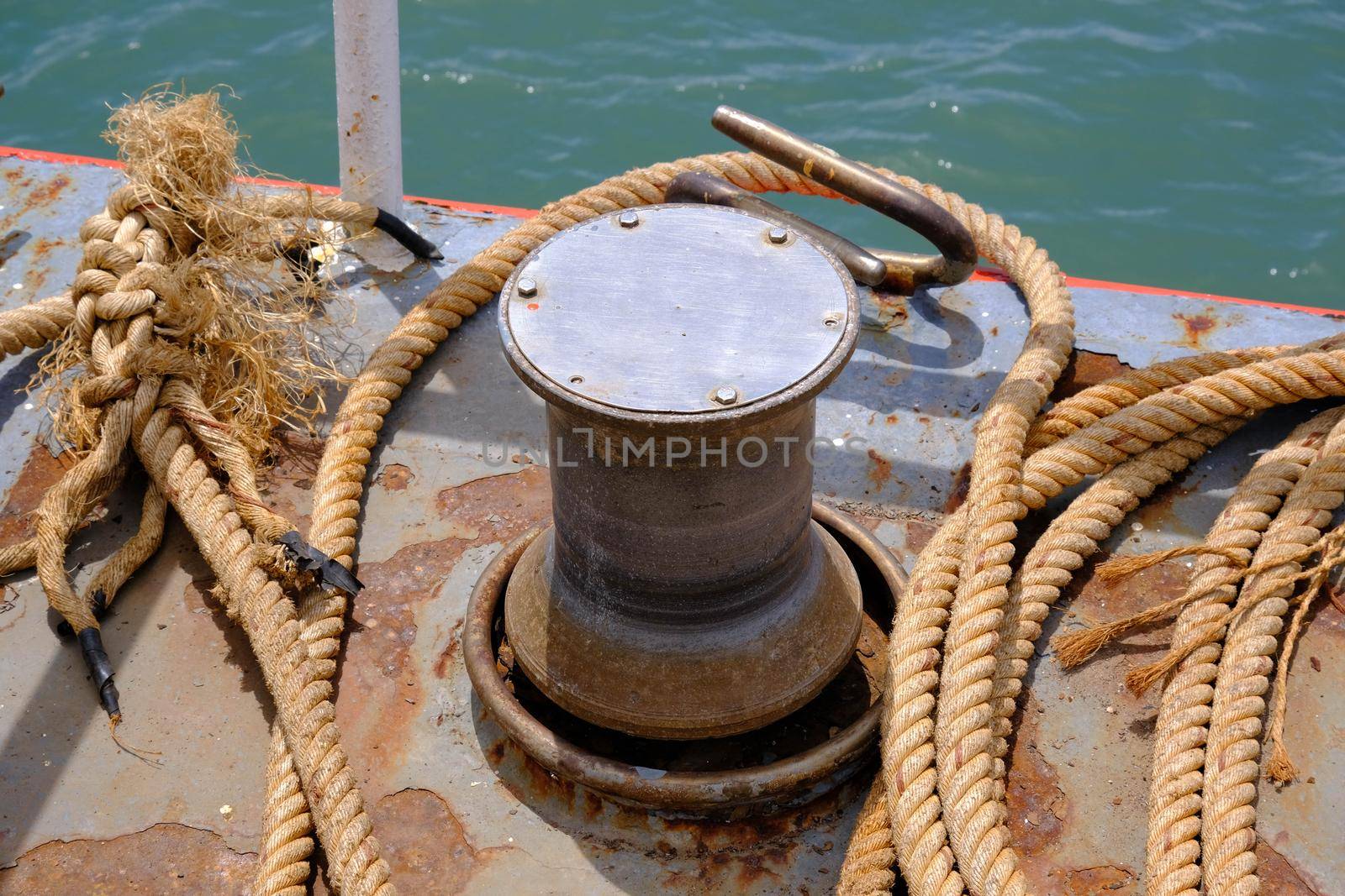 Close up of Old ropes and rusty bollard. rope and Marina bollard on moorage. The concept of mooring and water transportation by TEERASAK