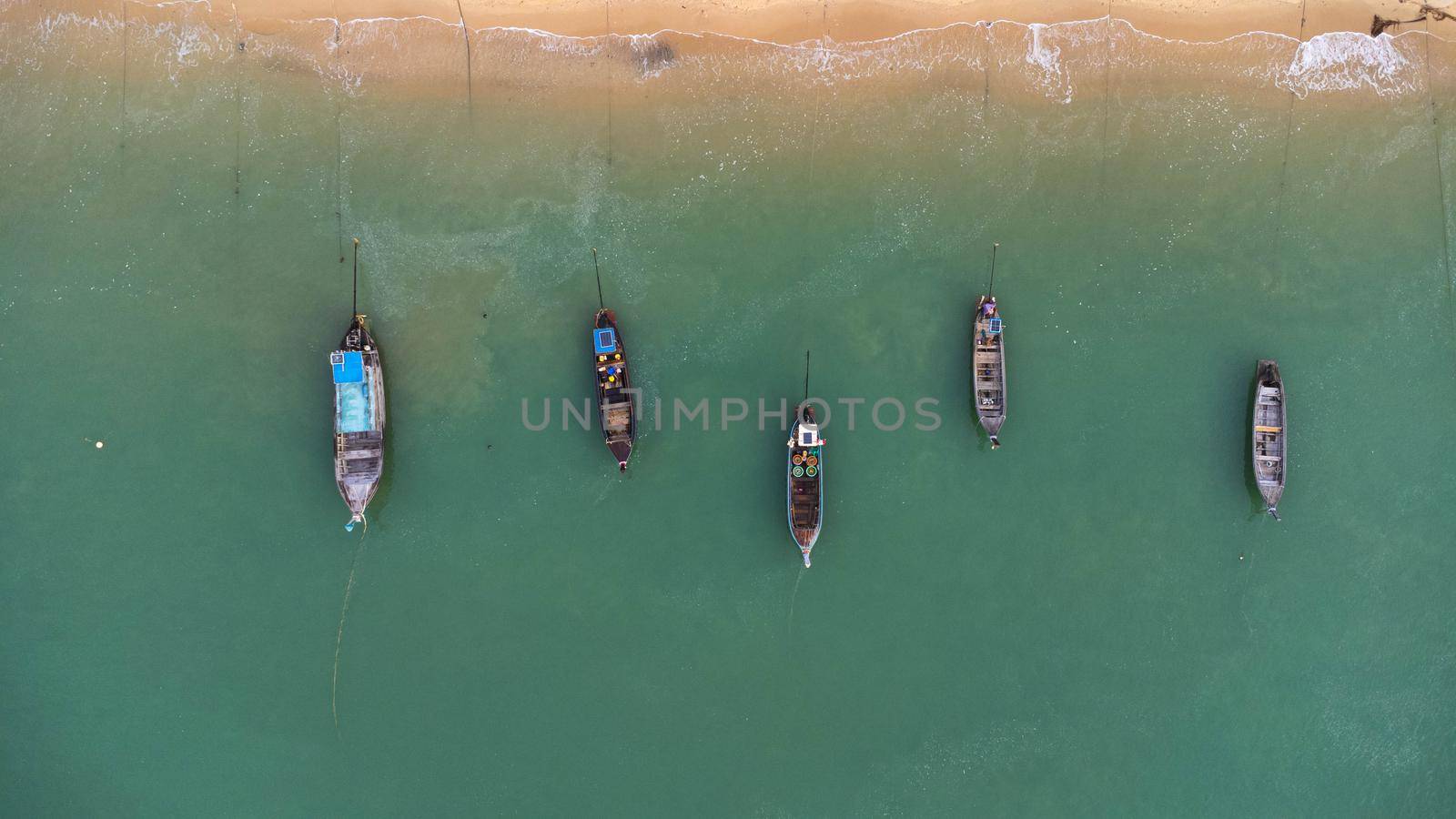 Many fishing boats near the seashore in tropical islands. Pier of the villagers on the southern island of Thailand. top view from drones.