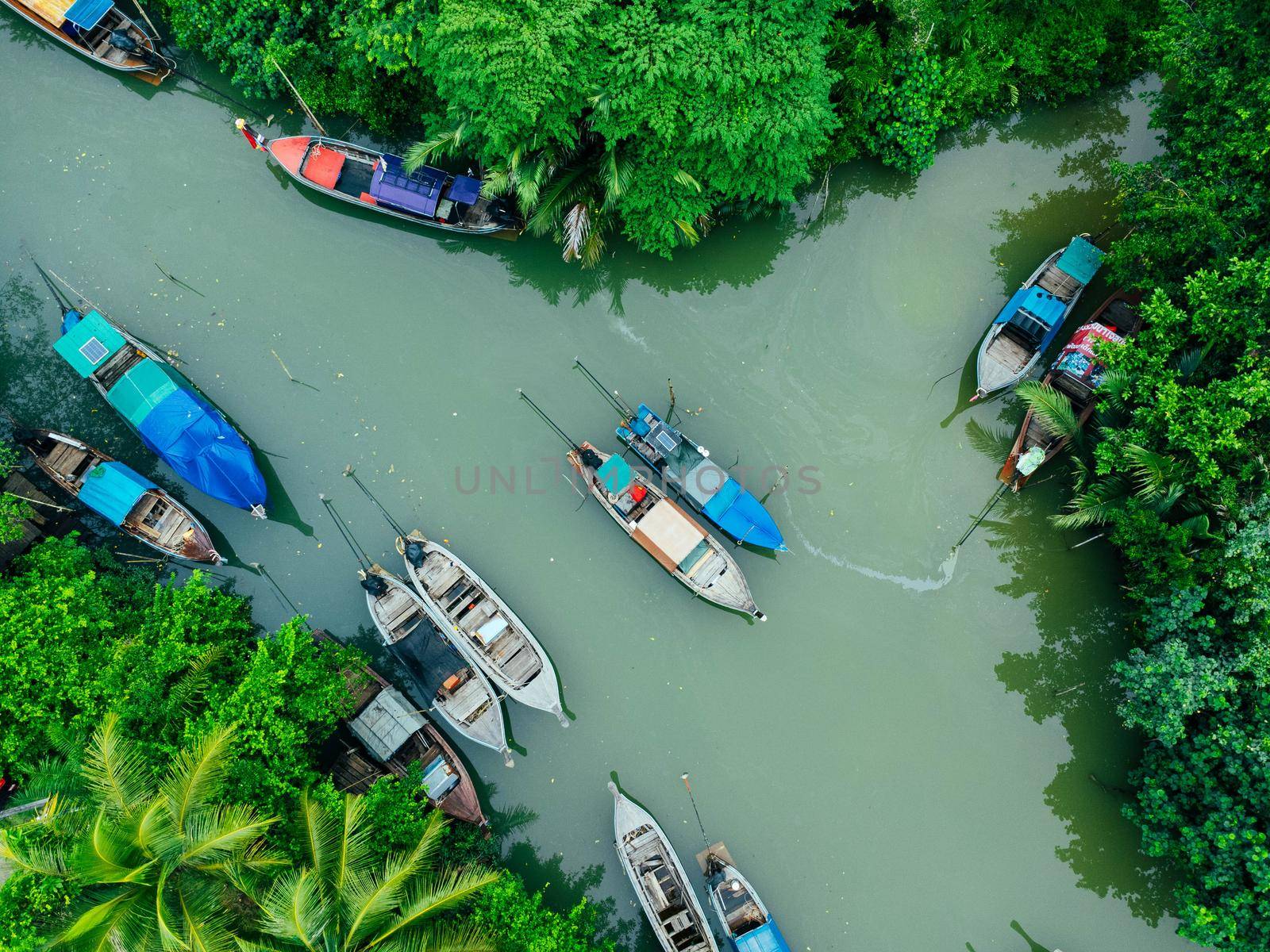 Aerial view from drones of fisherman boats and harbour in the river near the Andaman Sea in southern Thailand. Top view of many Thai traditional longtail boats floating in the mangrove landscape. by TEERASAK