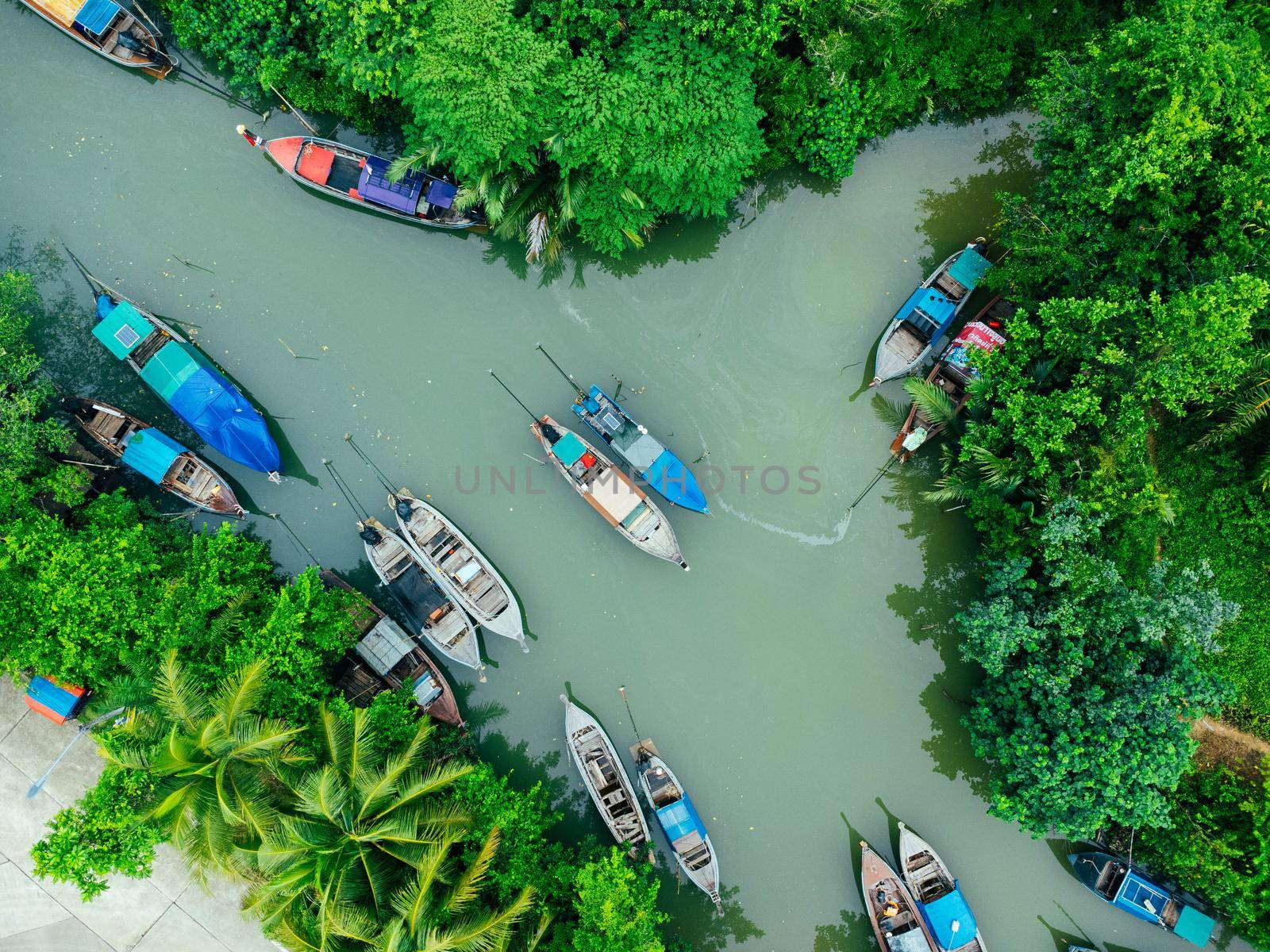 Aerial view from drones of fisherman boats and harbour in the river near the Andaman Sea in southern Thailand. Top view of many Thai traditional longtail boats floating in the mangrove landscape. by TEERASAK
