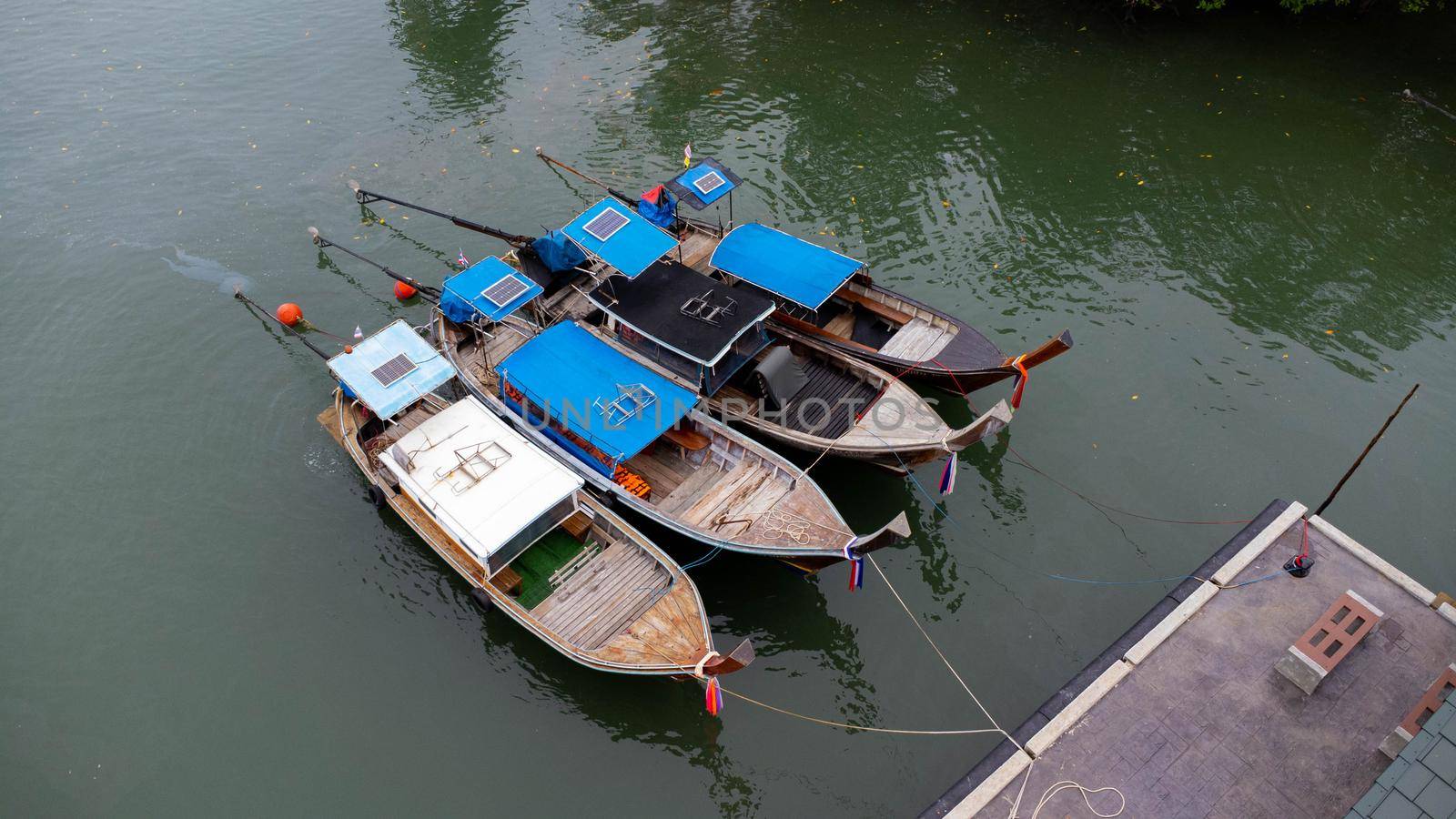 Aerial view of Thai traditional longtail fishing boats at the pier. Transportation and travel concept. by TEERASAK
