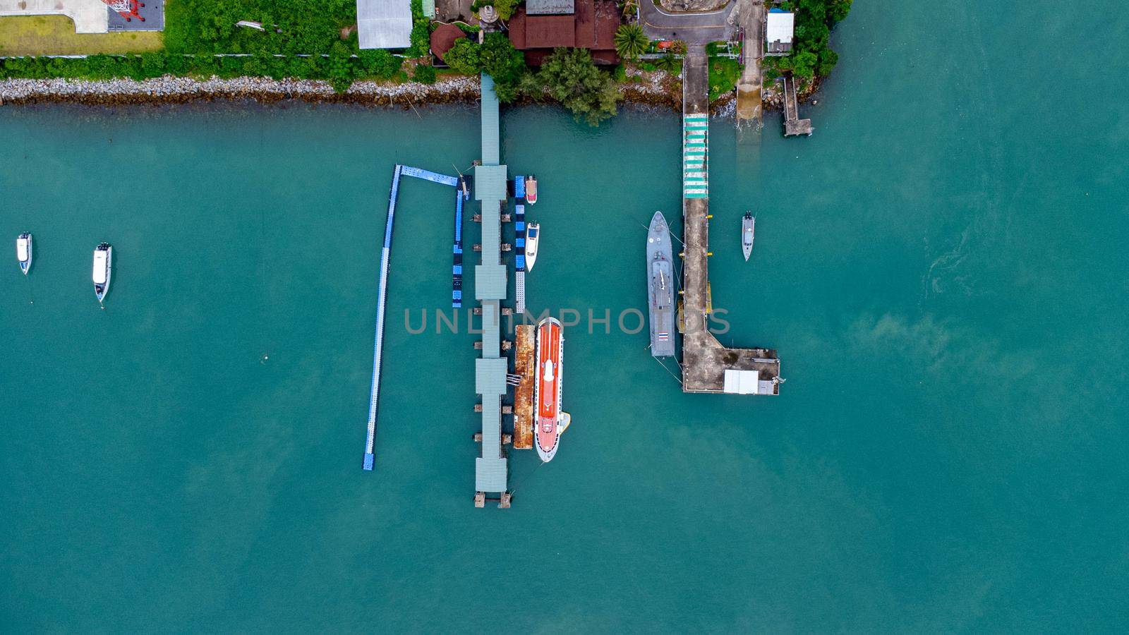 Aerial view from drone of commercial ship and cruise ship parked in the marina. Transportation and travel background, beautiful sea in summer.