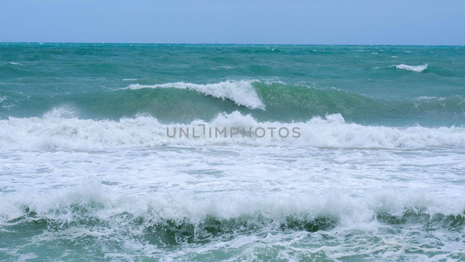 Beautiful ocean waves with blue and turquoise foam on a hot summer day. by TEERASAK