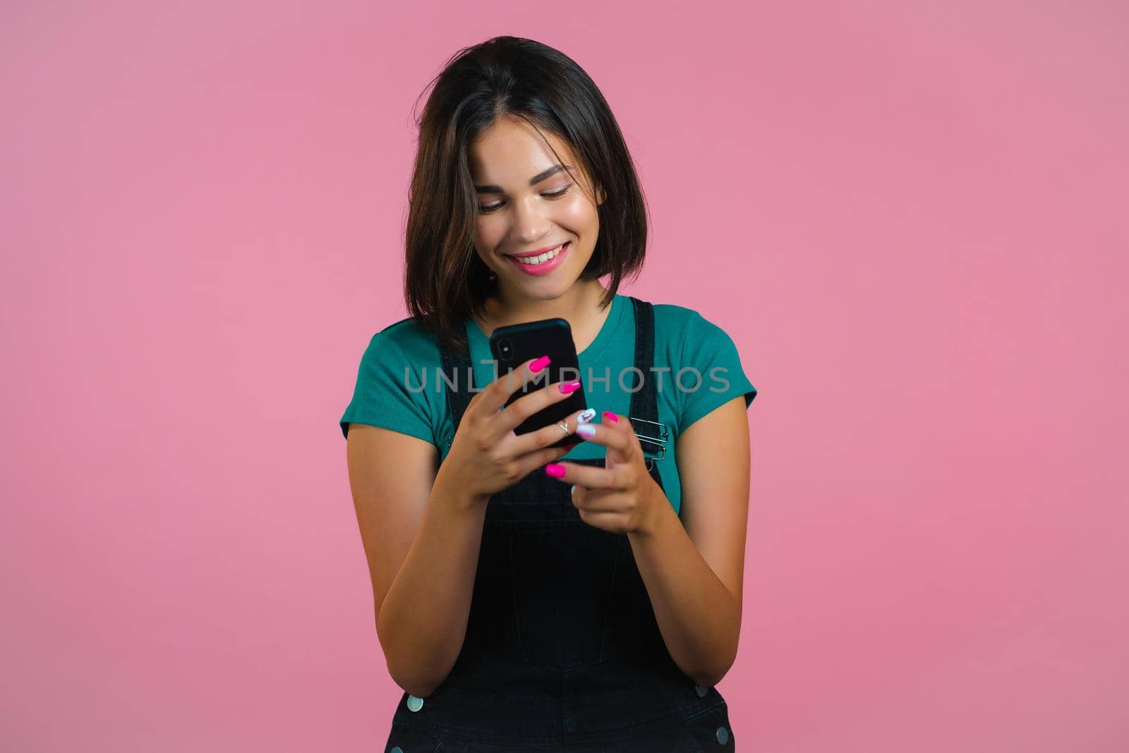 Attractive brunette woman receives happy notification on mobile phone. Girl using smartphone. Technology concept. by kristina_kokhanova