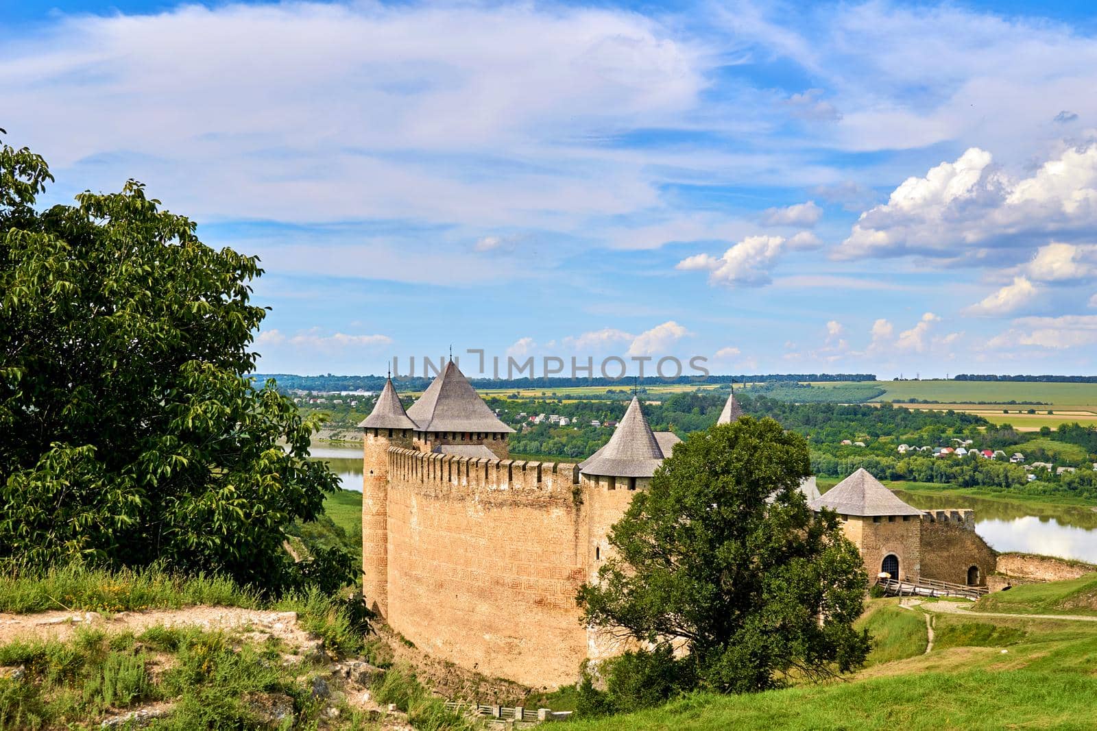 a military stronghold, especially a strongly fortified town fit for a large garrison. Old medieval fortress museum on green hills by the river