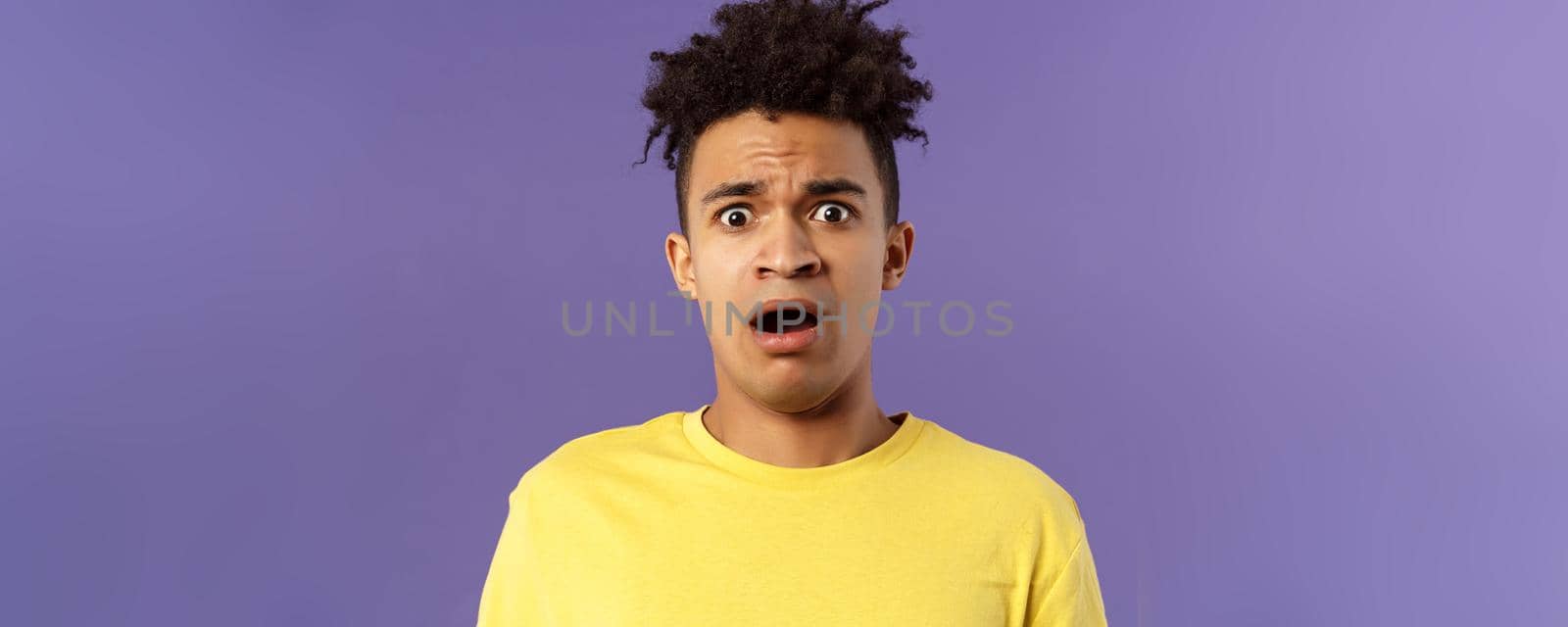 Close-up portrait of shocked, alarmed young man gasping, open mouth scared and frightened, staring camera concerned, facing troublesome shocking news, purple background by Benzoix