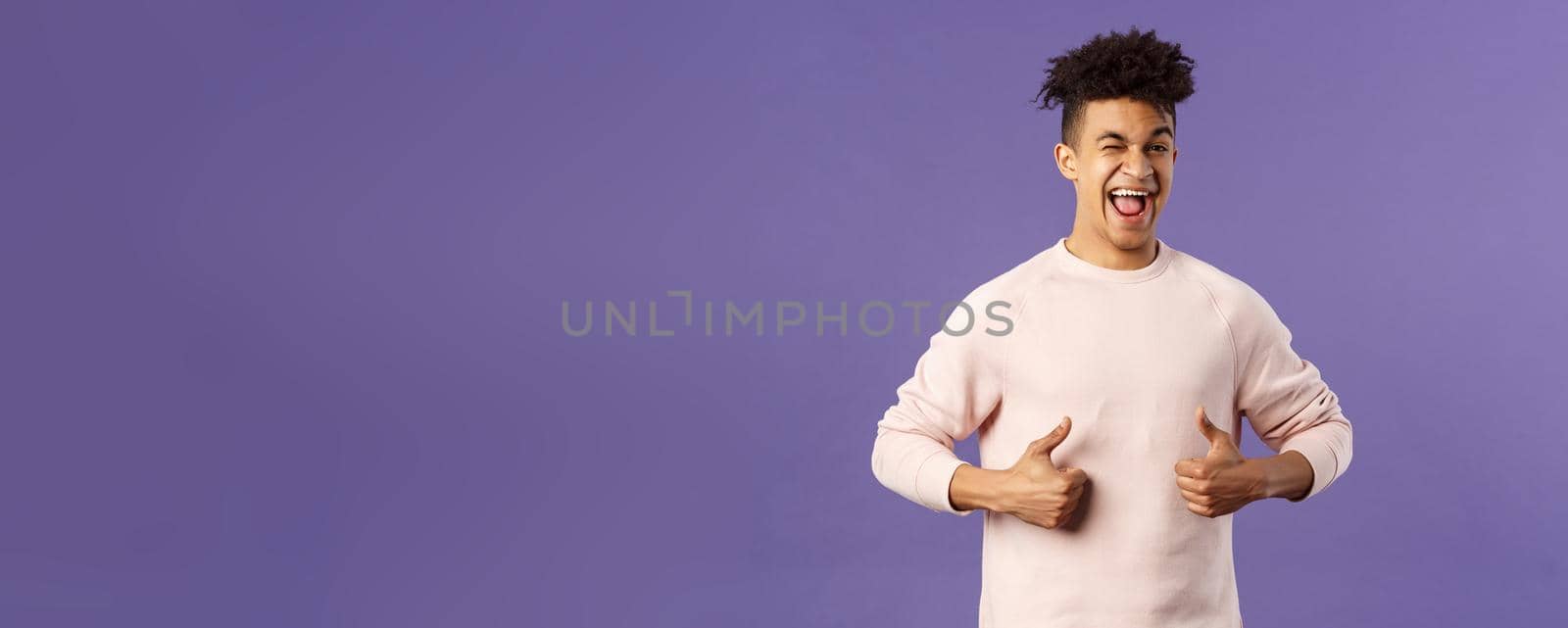 Portrait of enthusiastic lively, attractive young guy winking encourage join team, start career at this company, show thumbs-up with recommendation, give good advice, like and approve by Benzoix