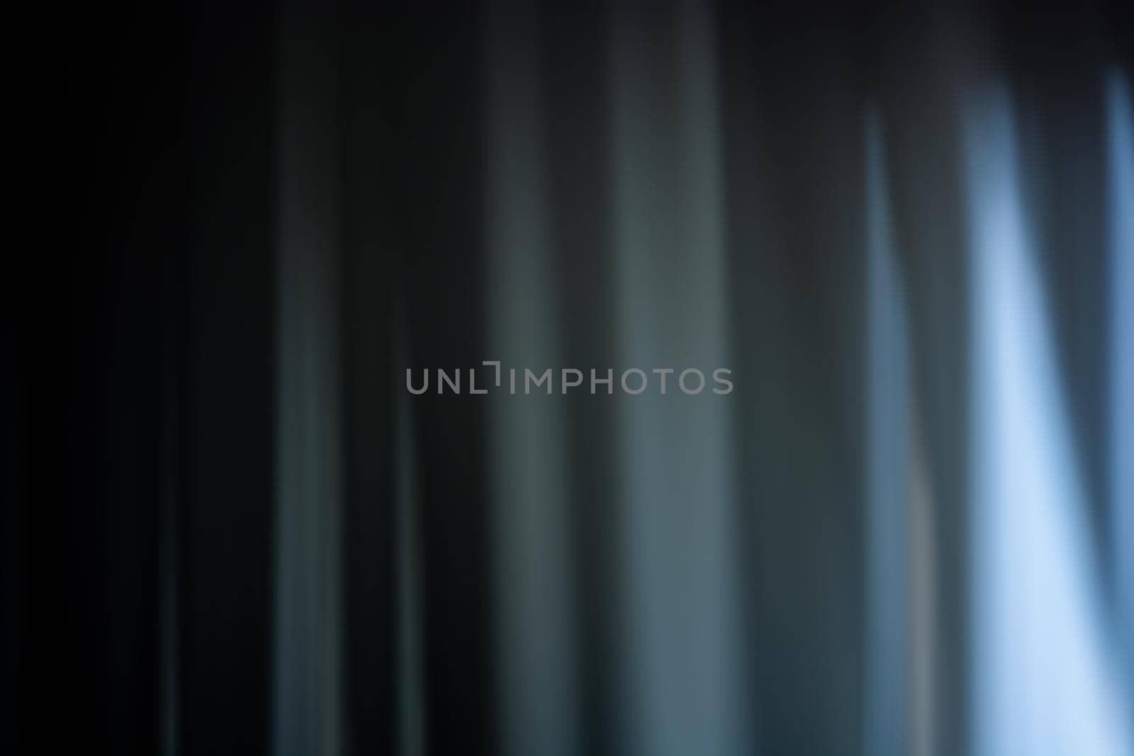 Soft blur of a curtain in dark blue tones with gaps. Wave abstraction. Background. Backdrop