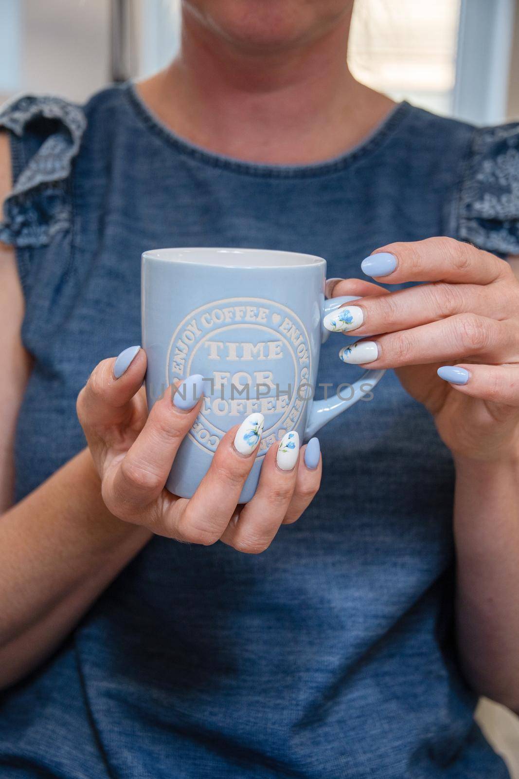 a young woman holds a blue cup of coffee, a beautiful summer manicure by KaterinaDalemans