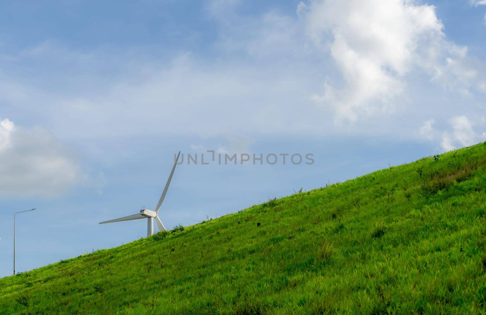 Wind energy. Wind power. Sustainable, renewable energy. Wind turbines generate electricity. Windmill farm on a mountain with blue sky. Green technology. Renewable resource. Sustainable development. by Fahroni