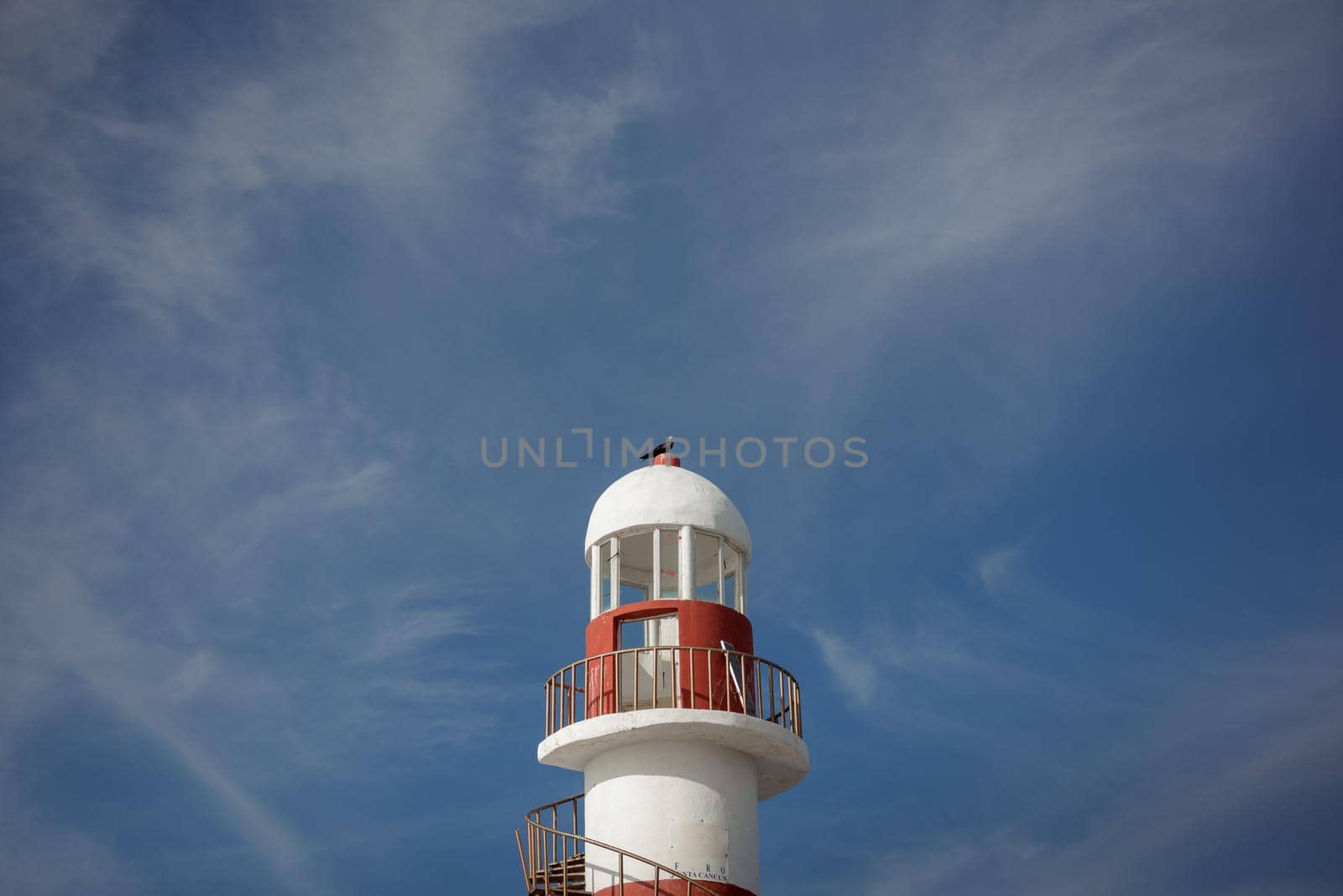 Lighthouse on a rocky shore in Cancun. Clear sky and blue sea.