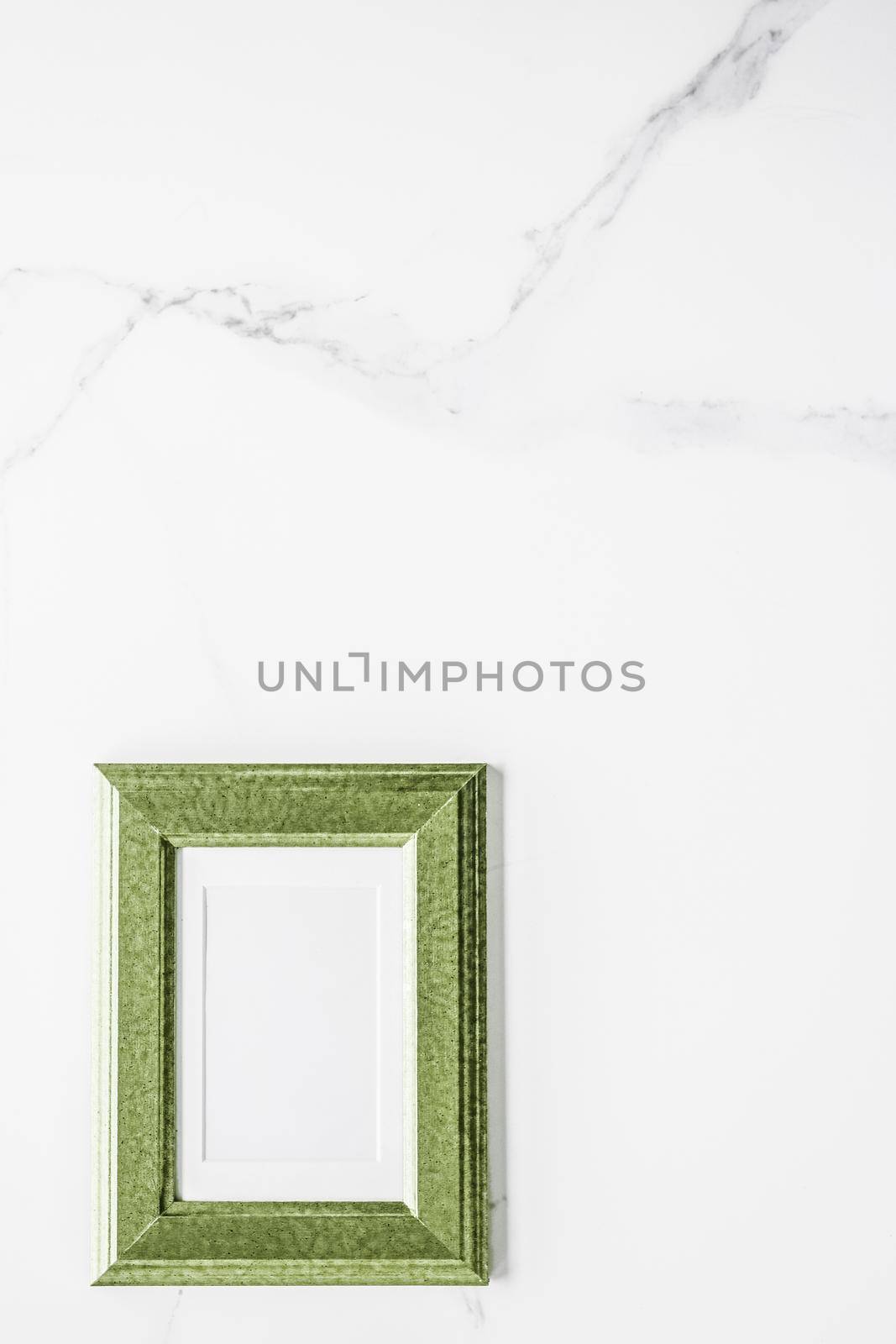 Green photo frame on marble, flatlay by Anneleven