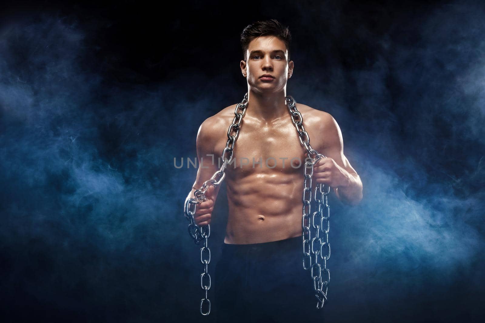 Teenager men sportsmen. Portrait of a brutal boy with chains. Athlete bodybuilder on black background. by MikeOrlov