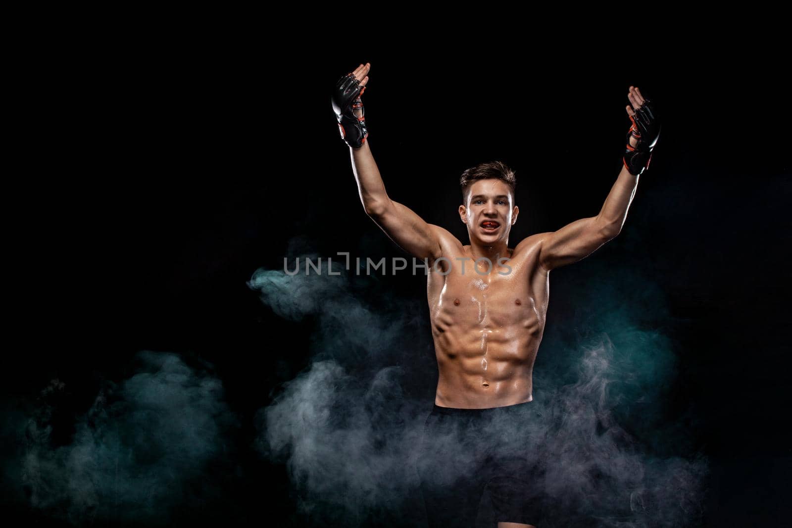 Happy sportsman teenager boxer fighting on black background with shadow. Copy Space. Boxing sport concept. by MikeOrlov