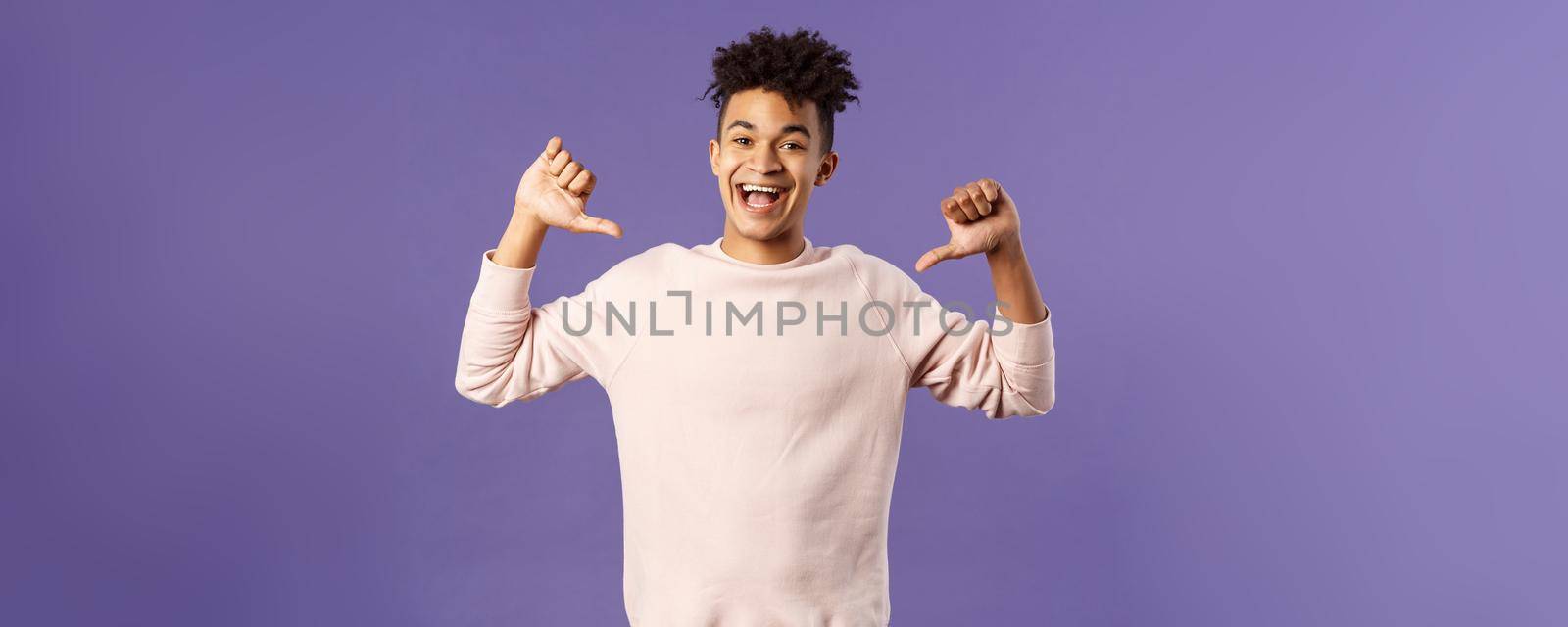 Portrait of confident young upbeat man, smiling bragging, being boastful about own accomplishments, indicate himself with proud rejoicing face, standing purple background.