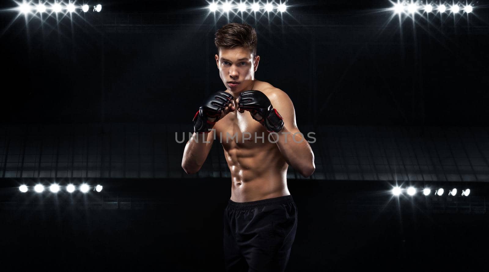 Sportsman teenager boxer fighting on black background with shadow. Copy Space. Boxing sport concept. by MikeOrlov