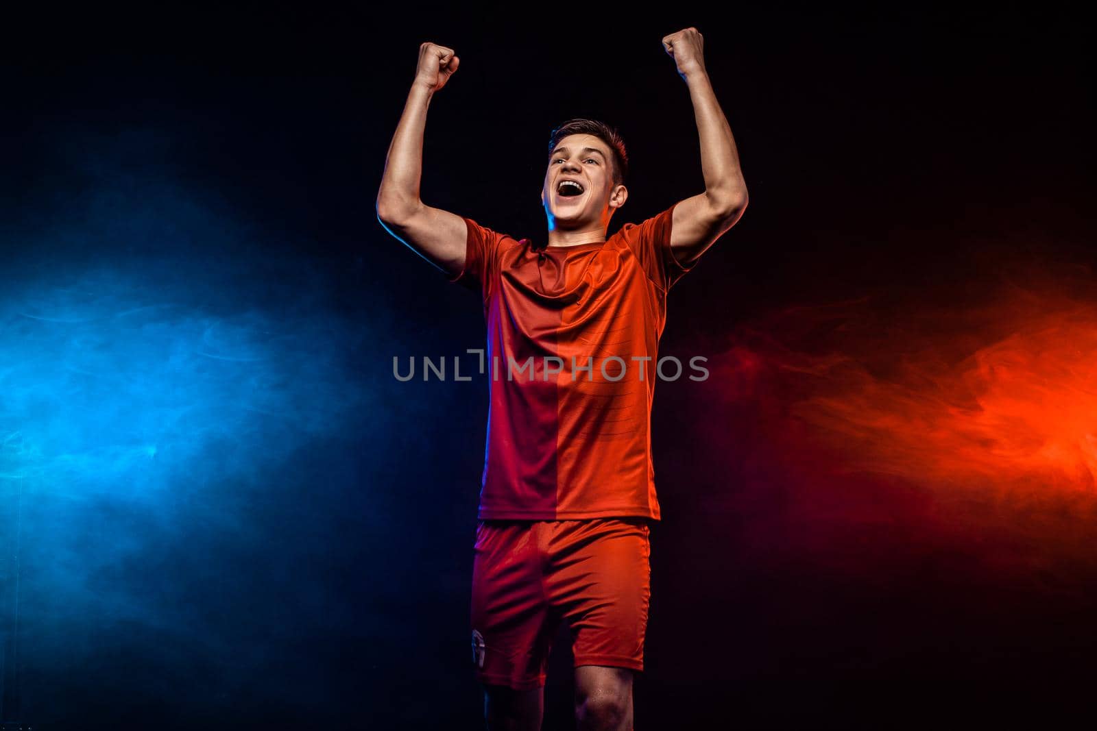 Happy teenager - soccer player. Boy in football sportswear after goal celebrating. Sport concept. by MikeOrlov