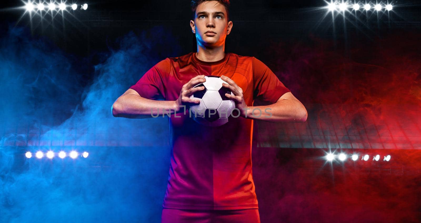 Kids in soccer sportswear on stadium with ball.