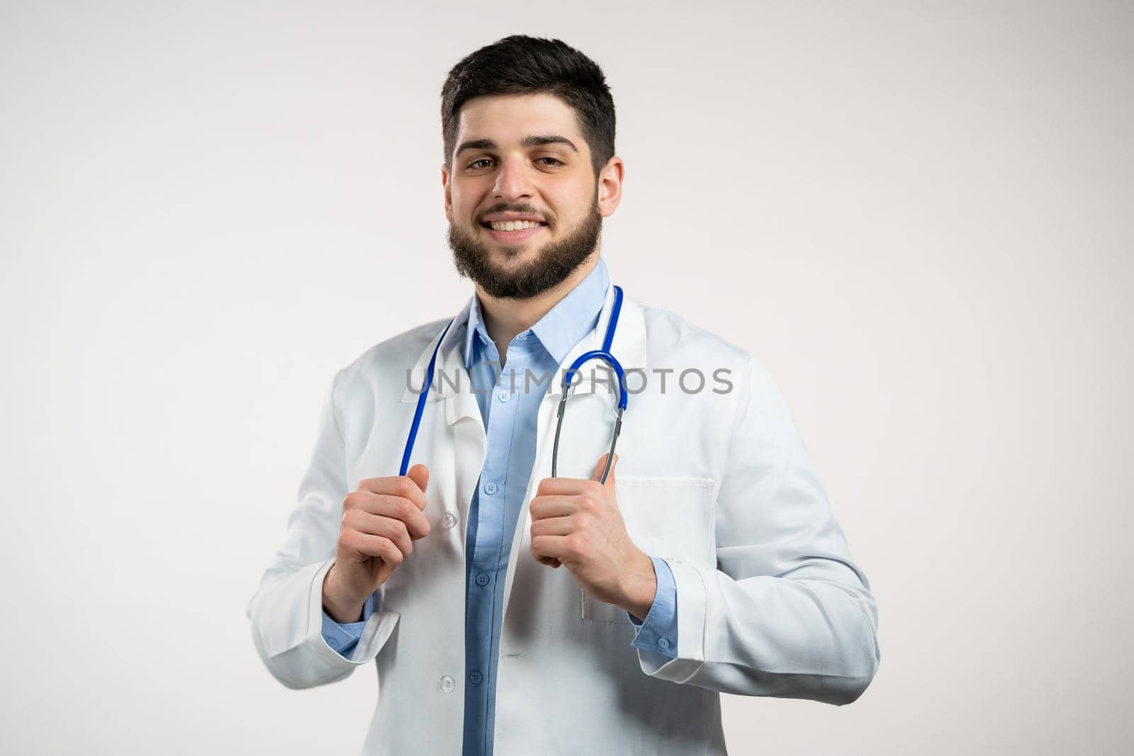 Portrait of cheerful doctor in professional medical coat. Man bearded doc isolated on white background. Medical staff concept. by kristina_kokhanova