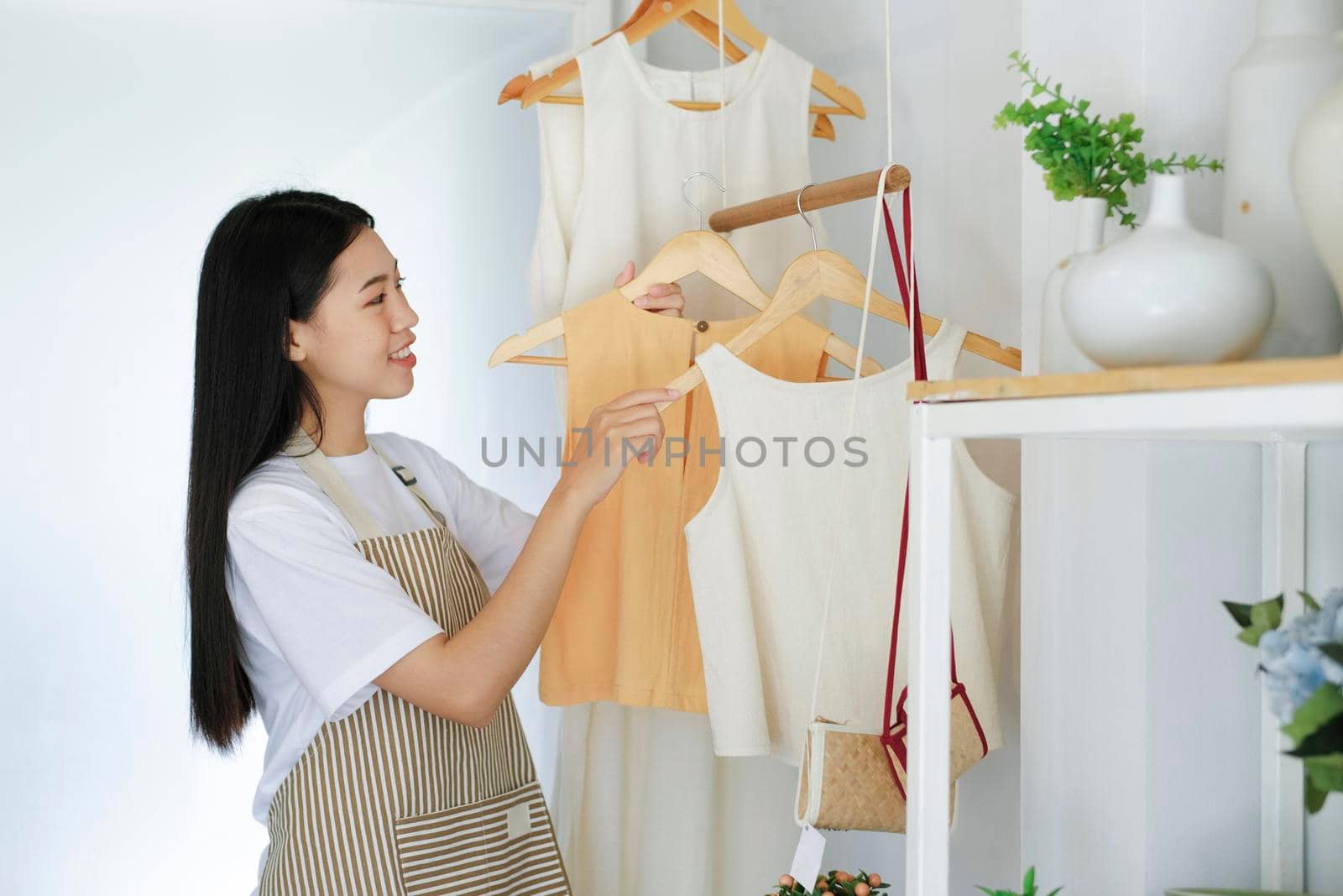 Young asian businessowner checking clothes in small business.Businessman checking inventory in stock room. Store house inspection.