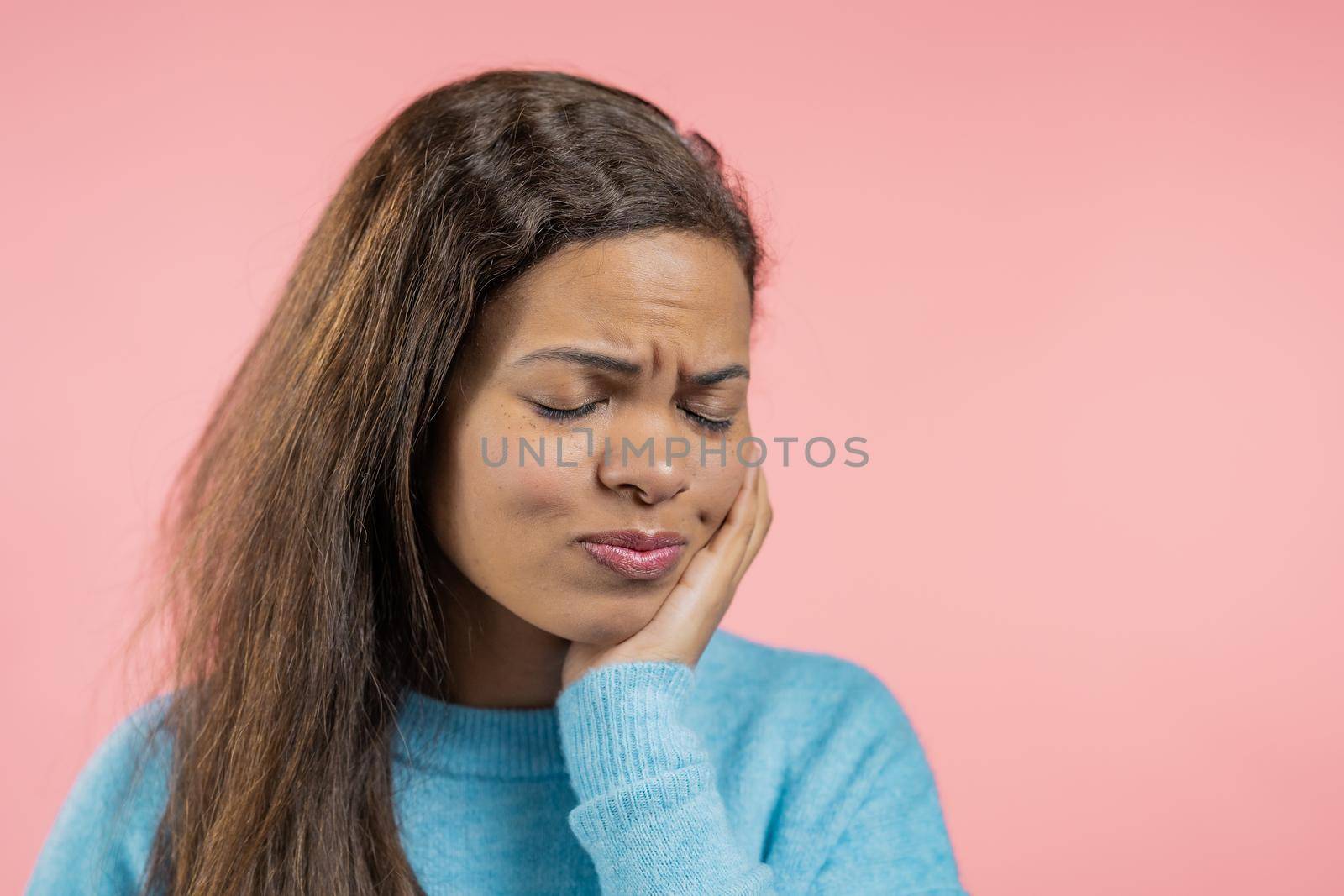 African mature woman have tooth pain on pink studio background. Toothache, dental problems, stomatology and medicine concept. High quality photo