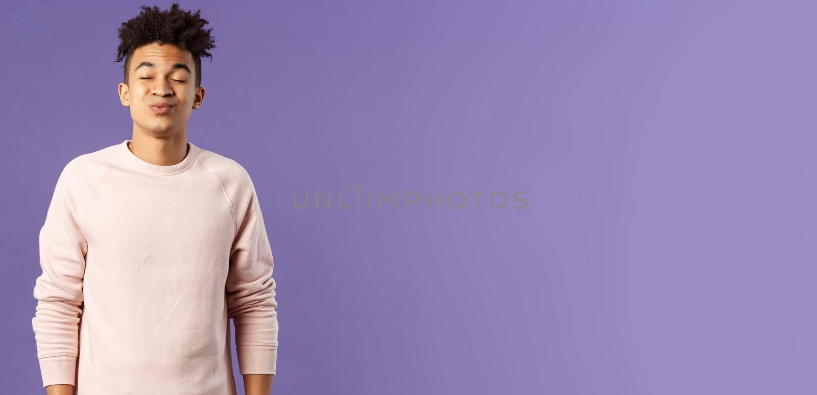 Portrait of cute and silly, young hispanic trying to kiss girl after date for the first time, leaning with folded lips and closed eyes towards her, making funny smile, standing purple background.