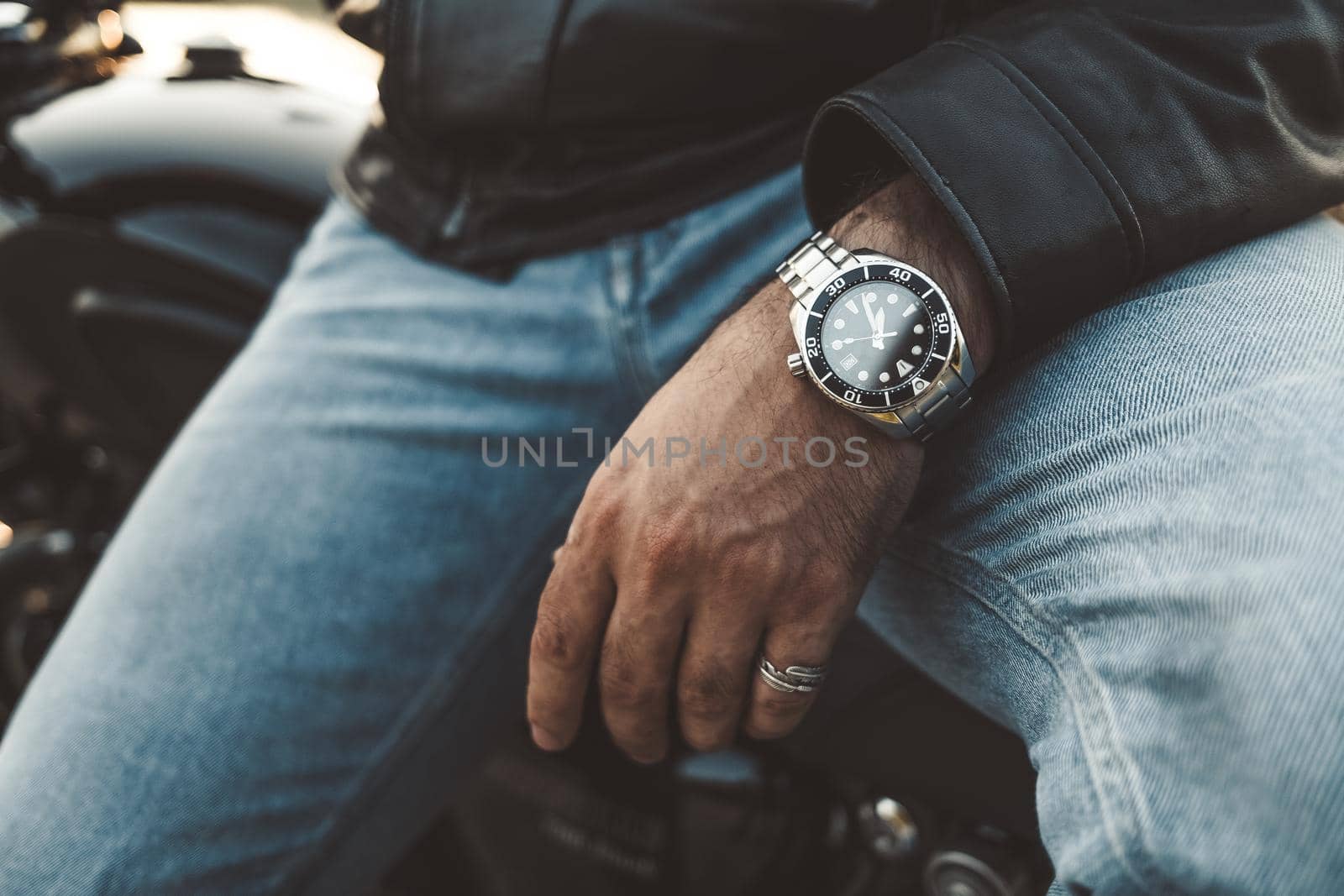 Male wrists, expensive watch close-up. Hands of young man sitting on motorcycle. Concept of luxury life, clock, punctuality, time by kristina_kokhanova