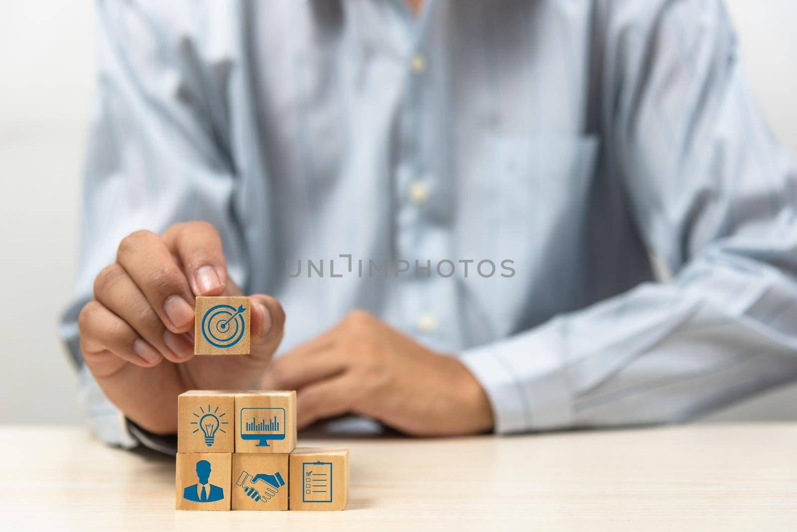 business strategy Action plan Goal and target icons with hand stack a wood cube block on a table. Copy space company development startup concept. by aoo3771