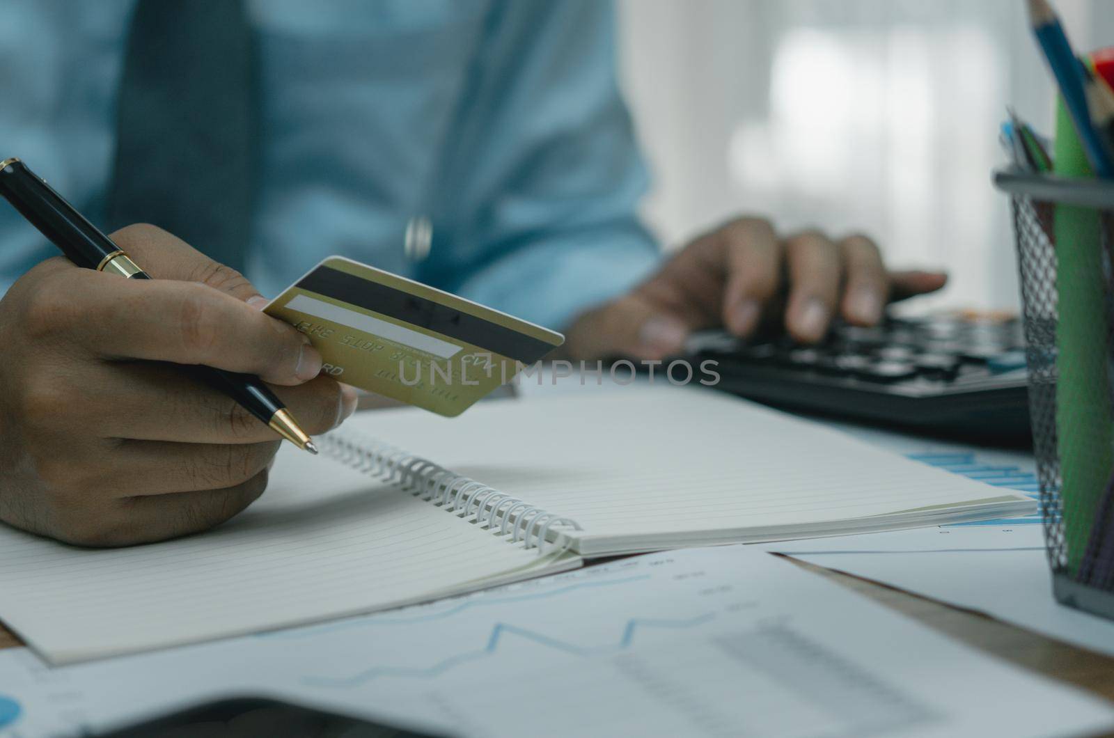 Man holding credit card with calculator payment finance banking shopping online commerce business concept.