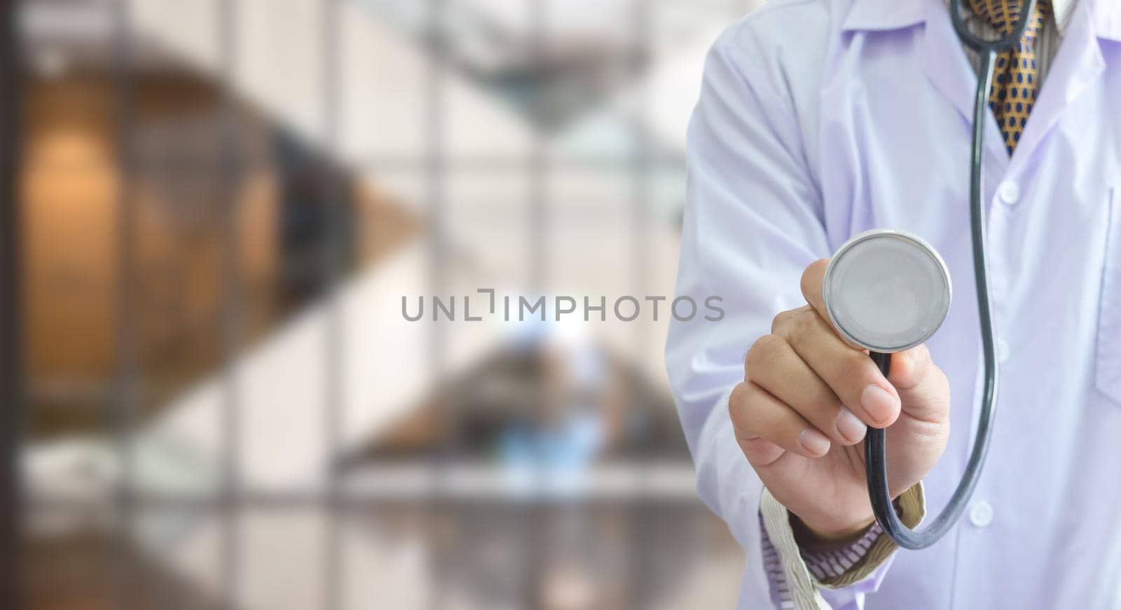 doctor uniform holding a stethoscope in hospital background copy space.Business health care concept.