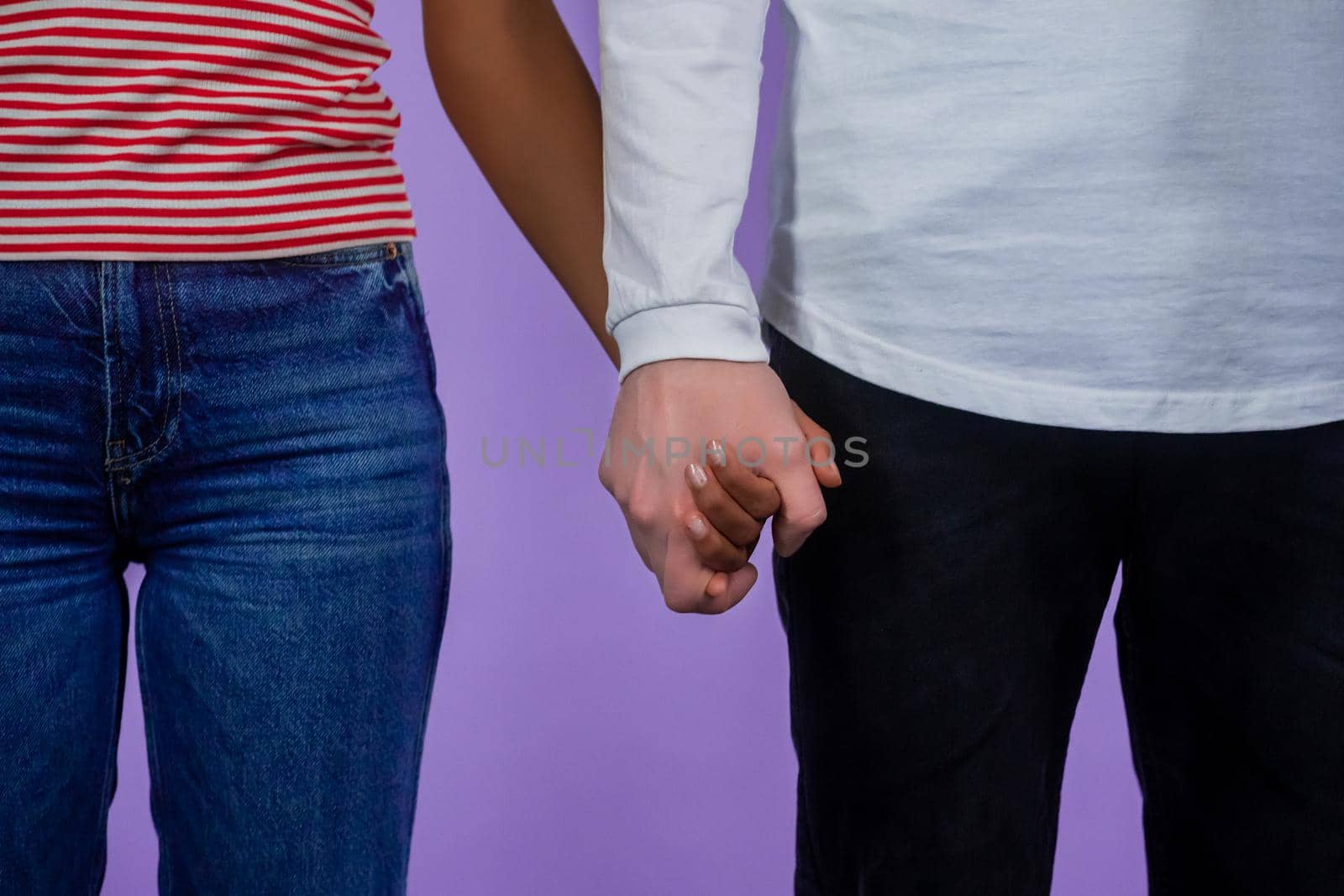 Hands of black woman and white man. Handshake close-up. Interracial friendship, anti-racism, fraternity, cooperation concept. Isolated on purple studio background. Ethnic diversity - Racial equality. by kristina_kokhanova