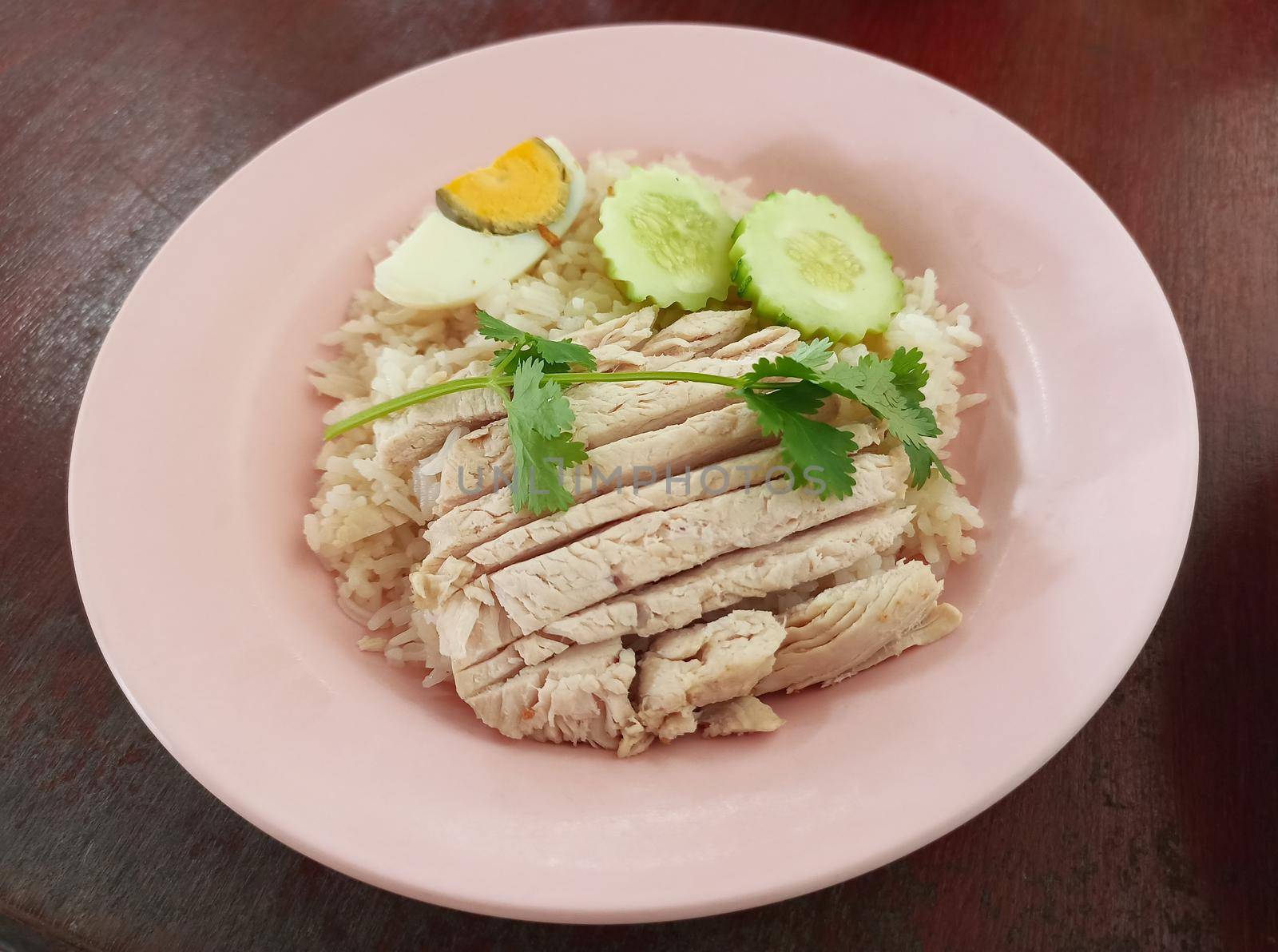 Chicken rice served with boiled egg and cucumber. The famous food of Koh Yao Yai, Phang Nga, Thailand. steamed rice topped with chicken