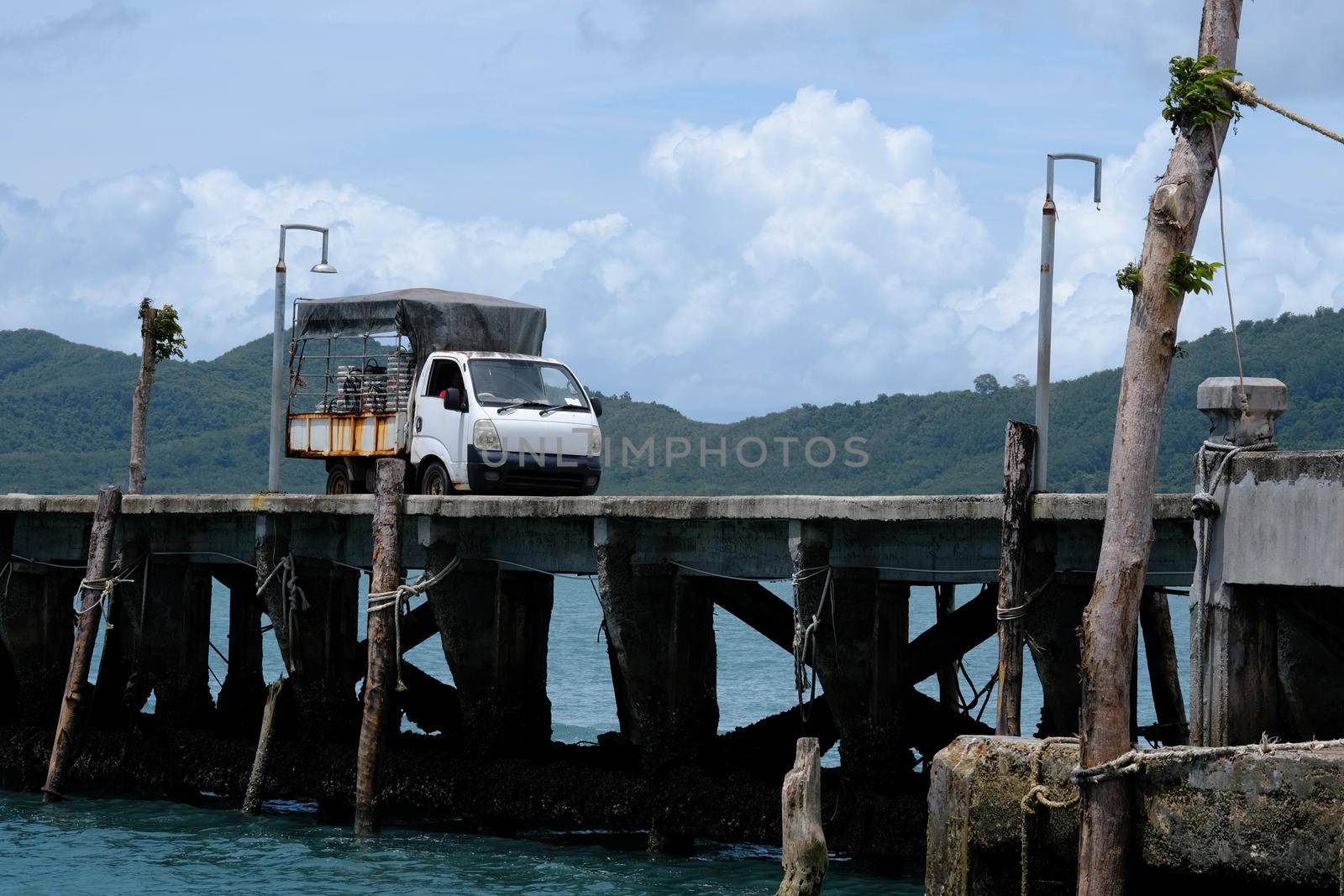 Pickup truck or old cargo truck on a small jetty on a tropical island of Thailand. Travel and transportation concept.