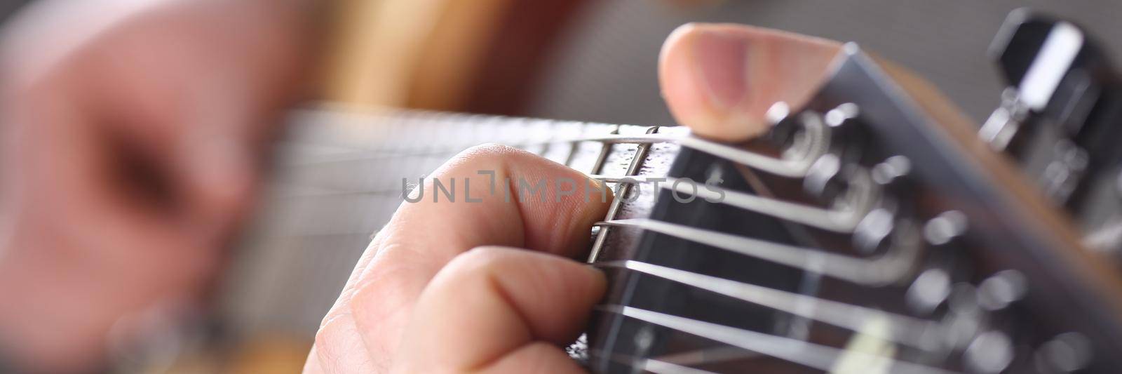 Male hands holding and playing wooden guitar by kuprevich