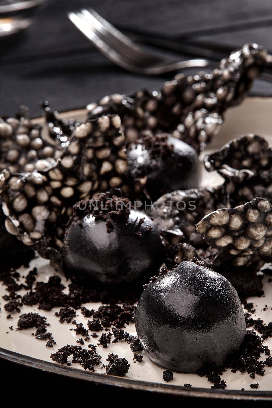 Appetizer with salmon pate, ink cuttlefish, crackers served on white tray over black wooden background. Close-up by nazarovsergey