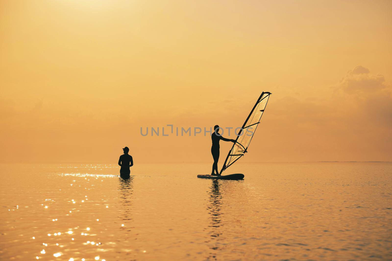 Sunset on the sea with silhouette of Girl with a Paddle on a SUP board by igor010