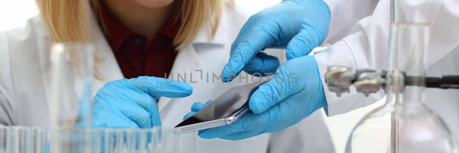 Scientist in chemical laboratory holds smartphone with a display in hand by kuprevich