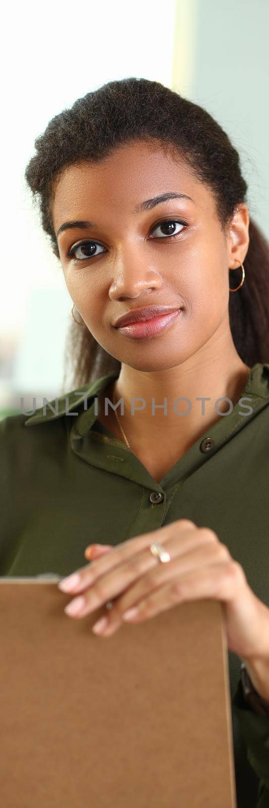 Beautiful black smiling businesswoman portrait holding business documents. Business consultant concept