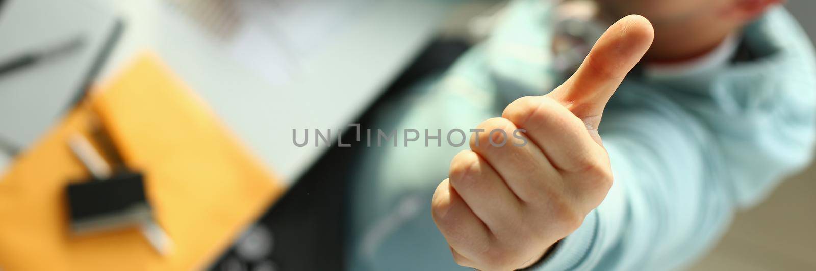 Young designer holding thumb up gesture closeup by kuprevich